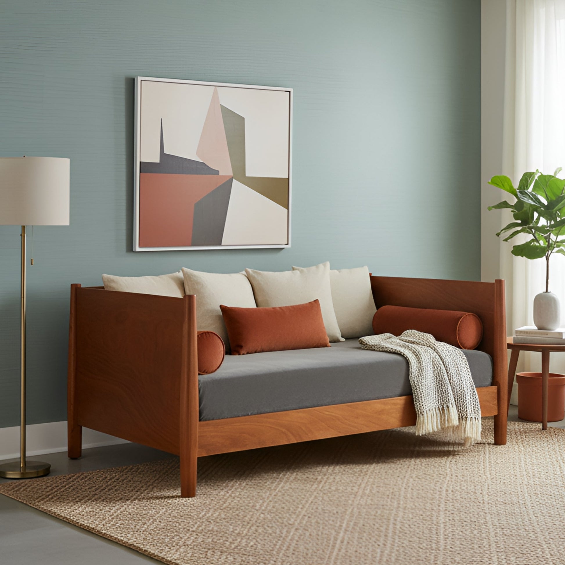 Flynn Day Bed in chestnut finish, styled with decorative pillows in a modern living room setting.