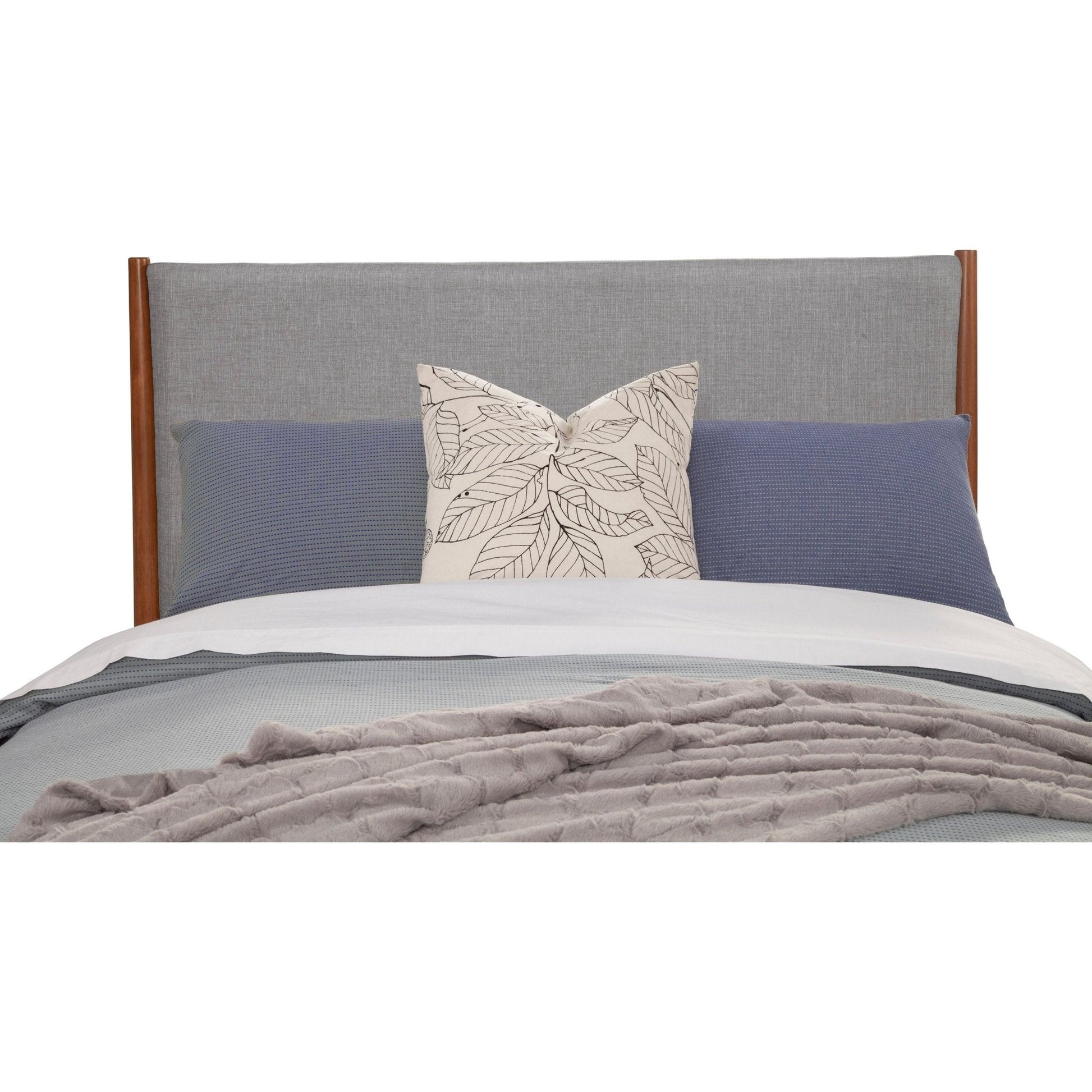 Flynn Panel Bed headboard featuring a chic design with decorative pillows in grey and blue.