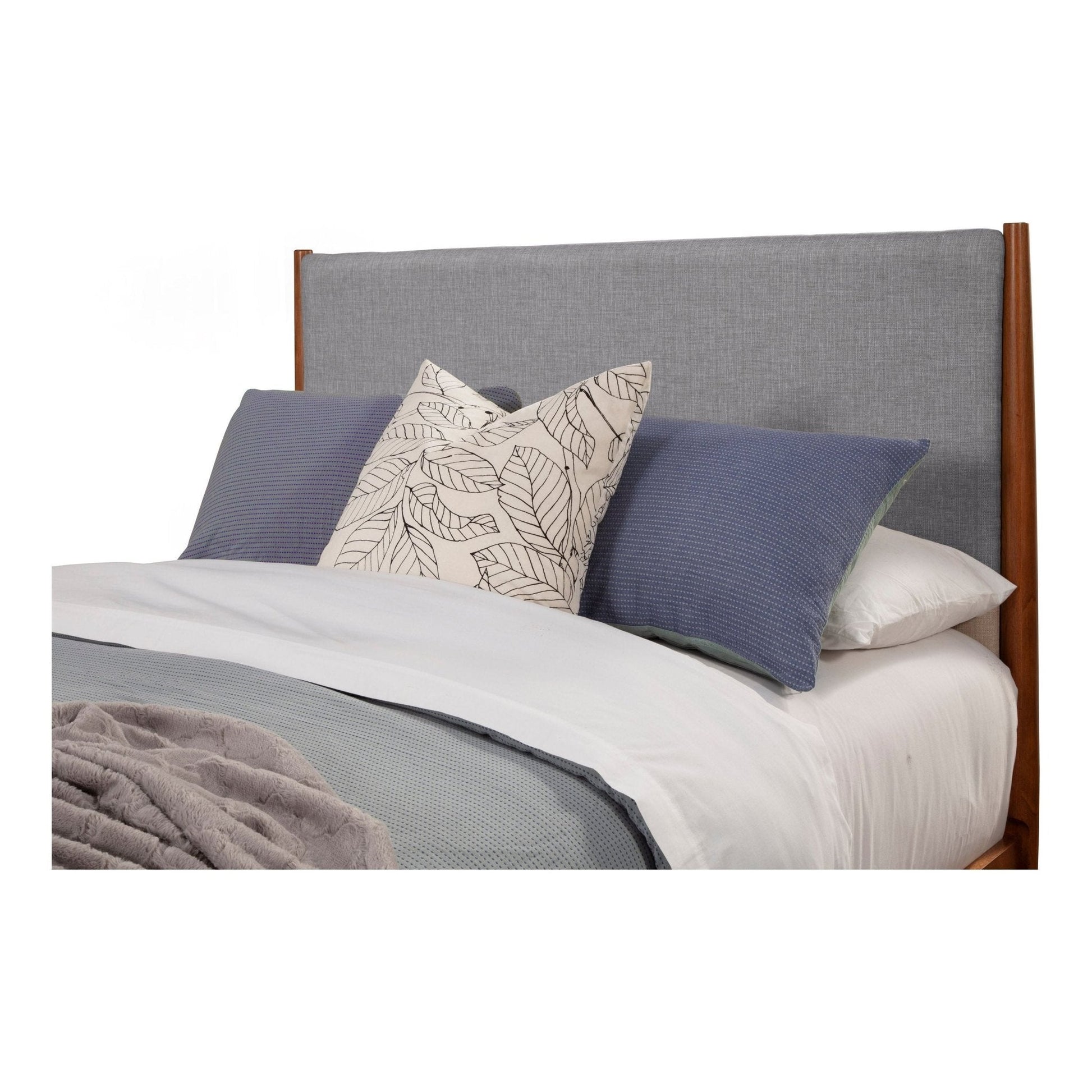 Flynn Panel Bed headboard with grey fabric and decorative pillows in a cozy bedroom setting.