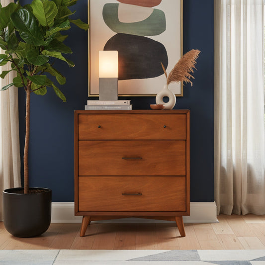 Flynn Small Chest in chestnut finish, styled with decorative items and a plant against a blue wall.