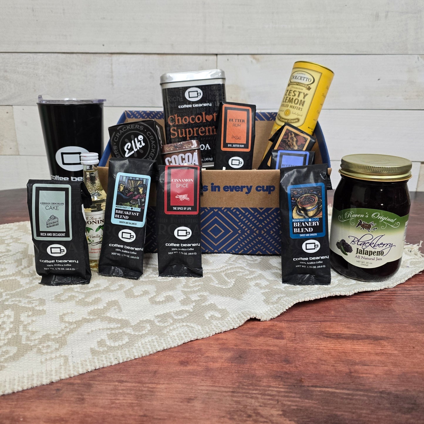 Gourmet Favorites Gift Basket featuring premium coffee blends and gourmet snacks on a lace tablecloth.