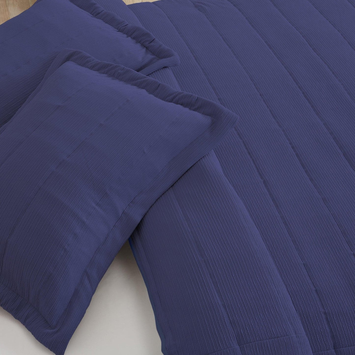 Blue textured comforter and pillow on a bed