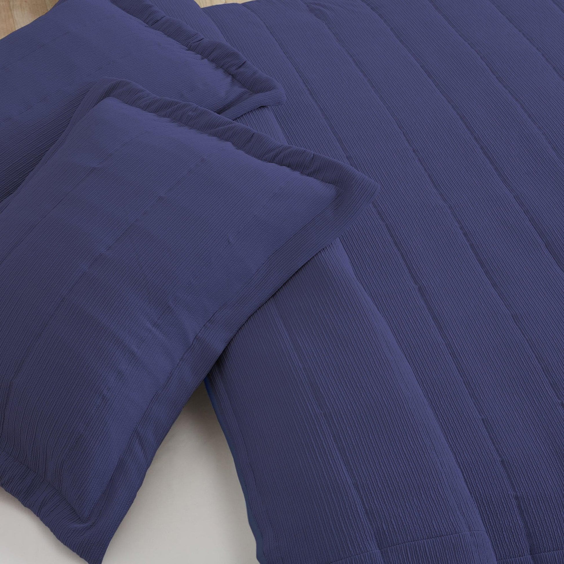 Blue textured comforter and pillow on a bed