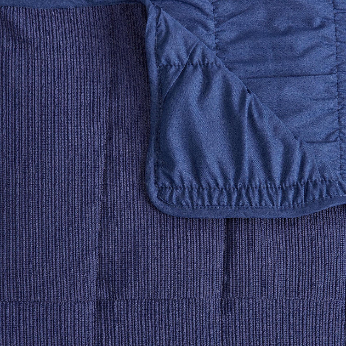 Close-up of a textured blue fabric with a folded corner
