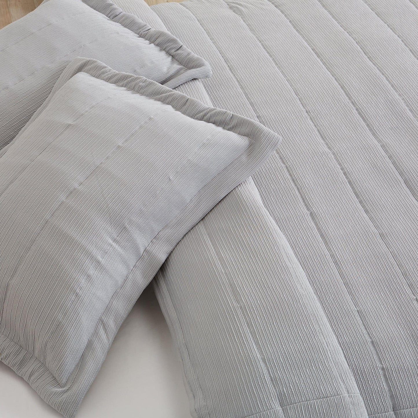 Gray textured comforter and pillows on a bed