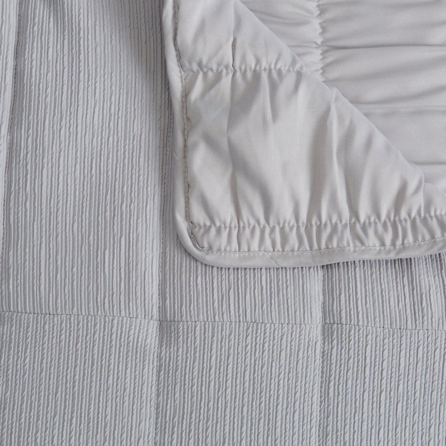 Close-up of textured gray fabric with a folded corner