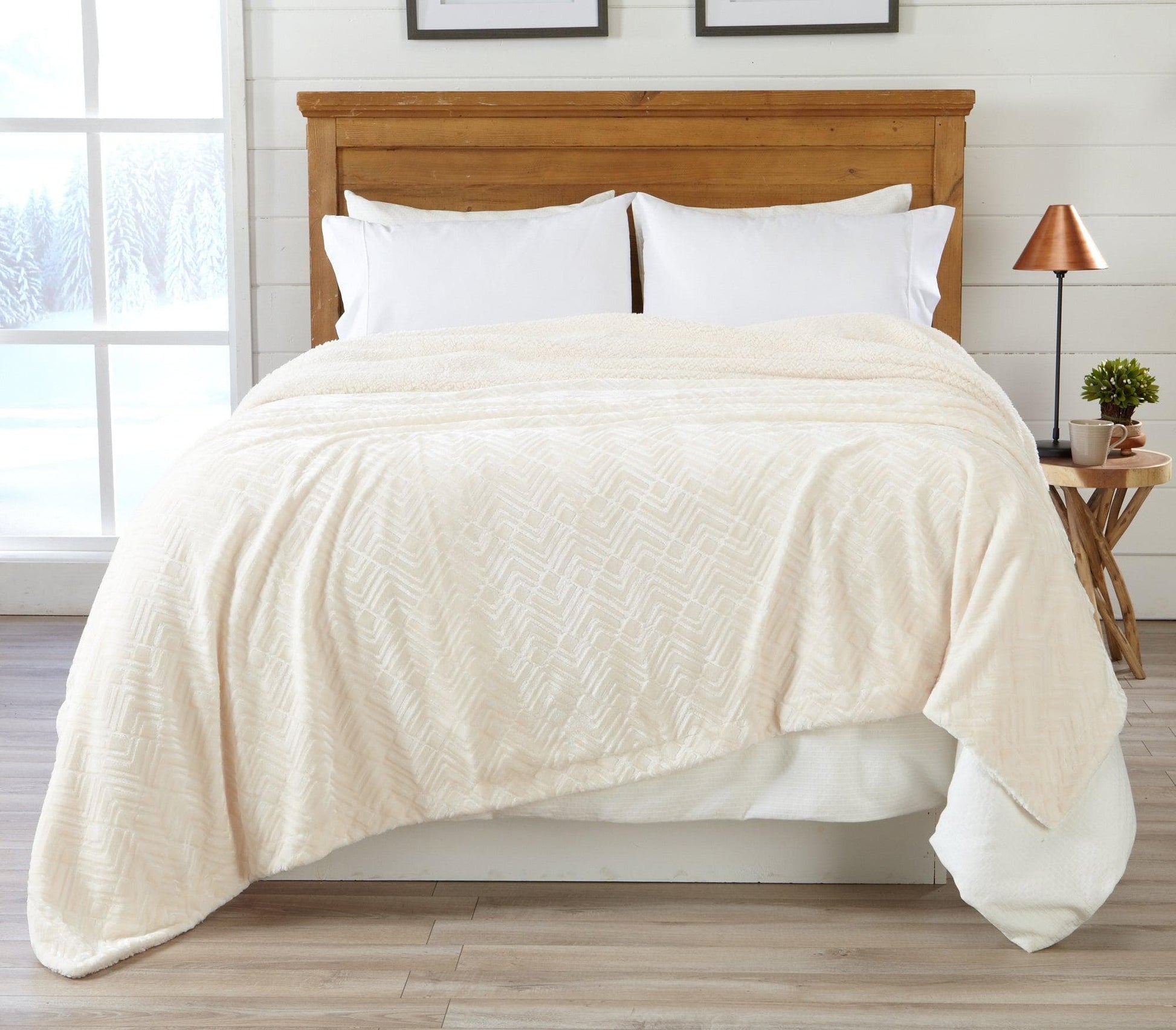 Beige comforter on a bed in a room with a window and side table.