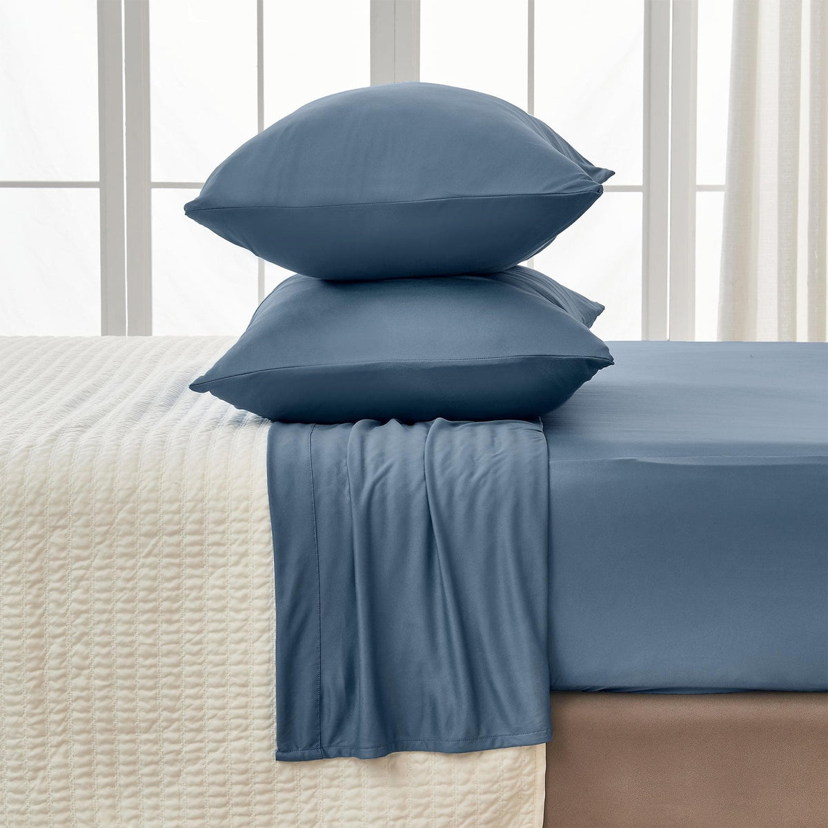 Blue bedding set with pillows and duvet on a bed