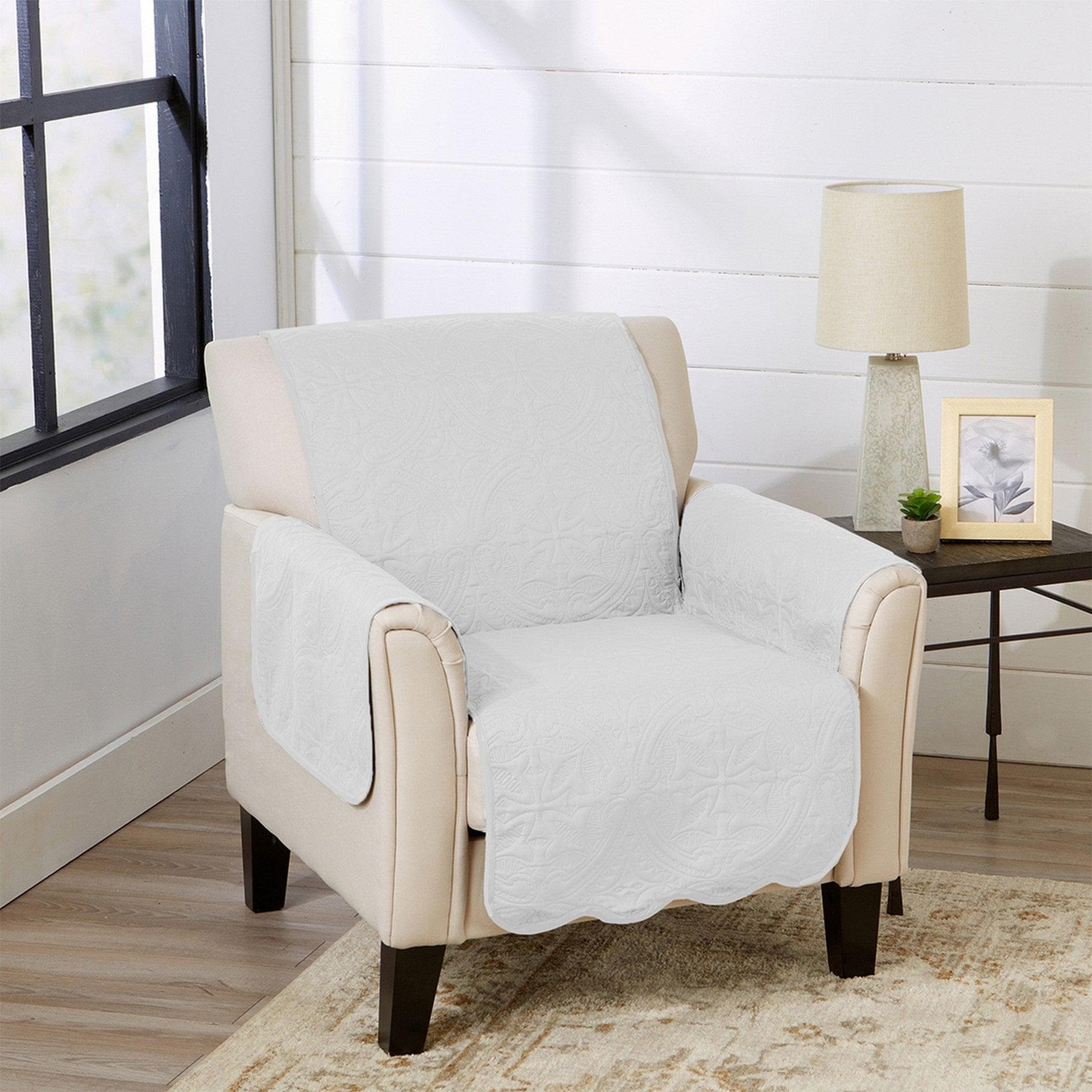 Beige armchair with a white quilted cover in a living room setting.