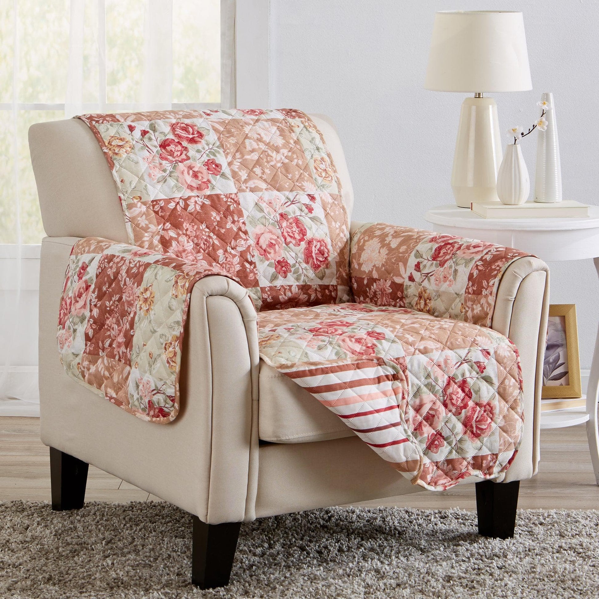 Floral patchwork quilt draped over a beige armchair in a living room setting.