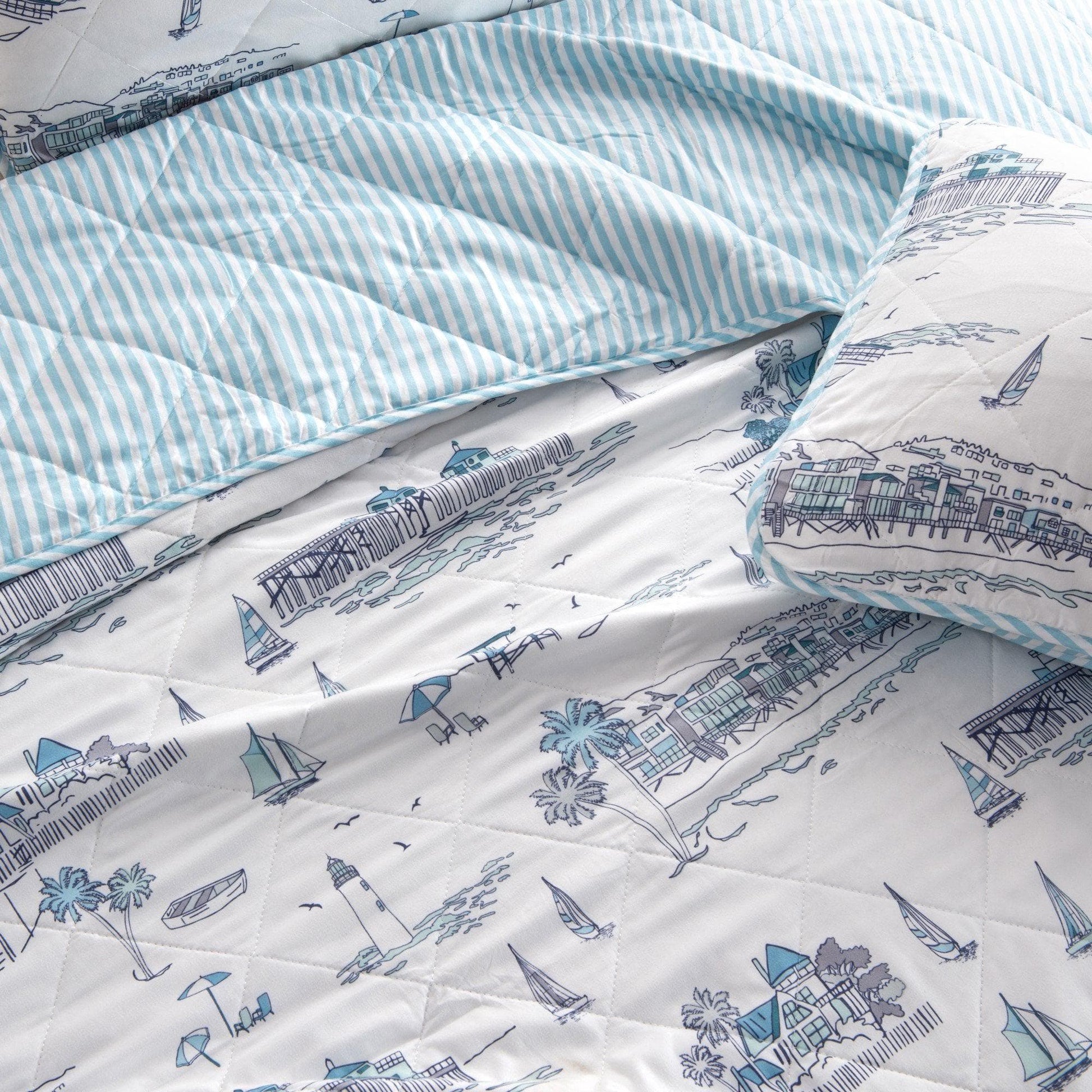Quilt with blue and white striped pattern and coastal design on a white background