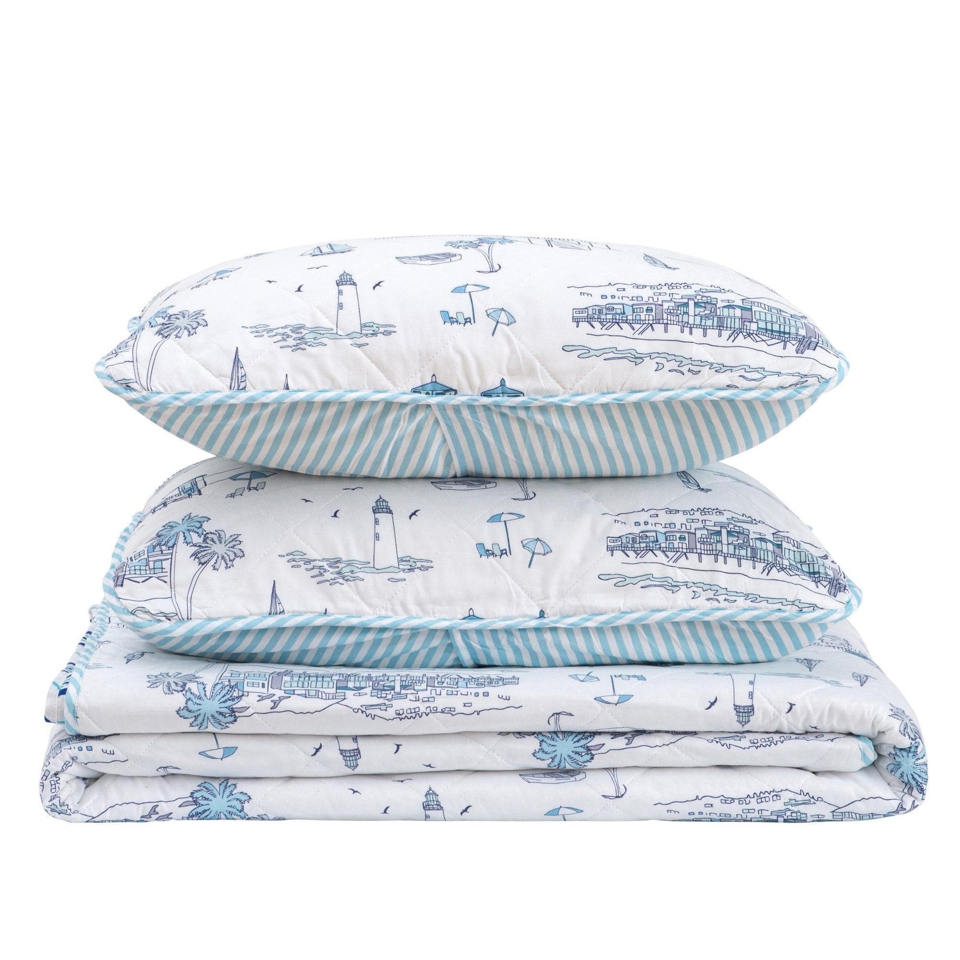 Stack of pillows and a blanket with nautical pattern on a white background