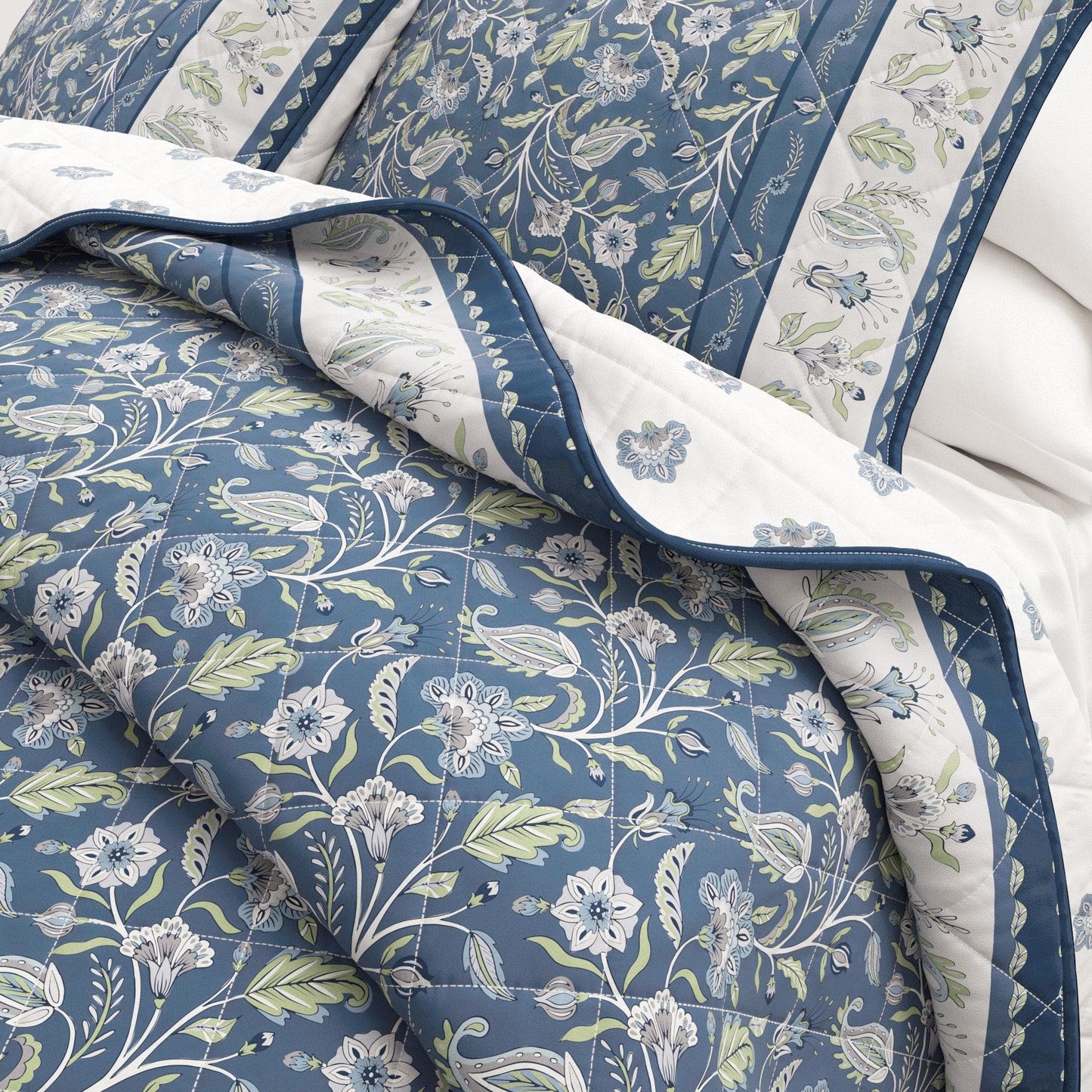 Floral patterned quilt with blue and green colors on a white background