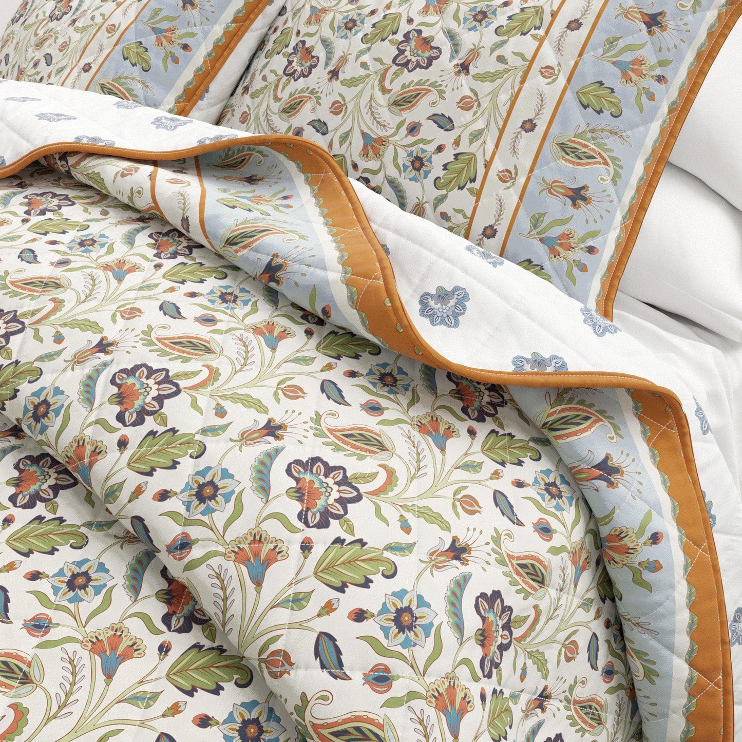 Floral patterned quilt with orange border on a bed
