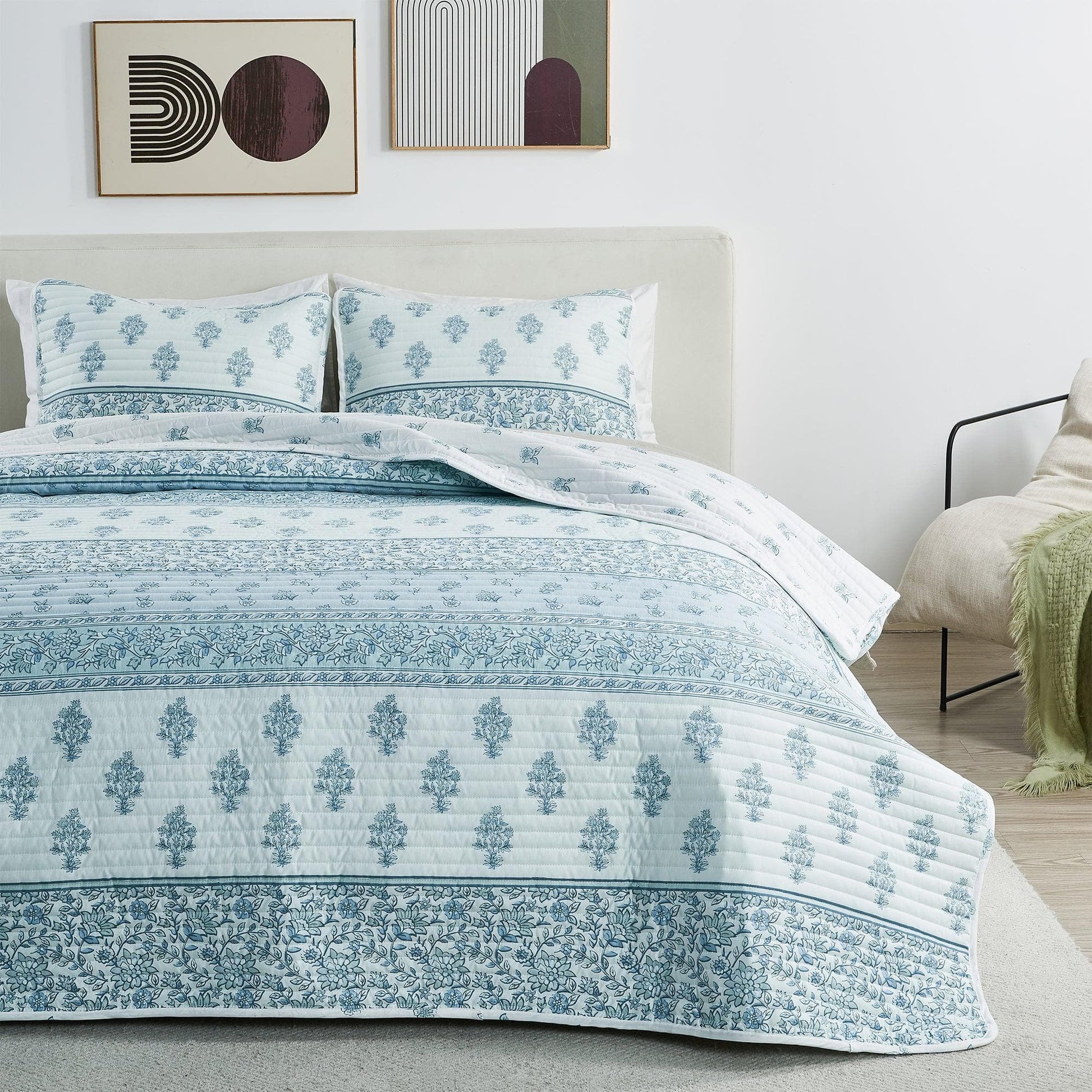 Bed with blue and white patterned bedding in a bedroom setting