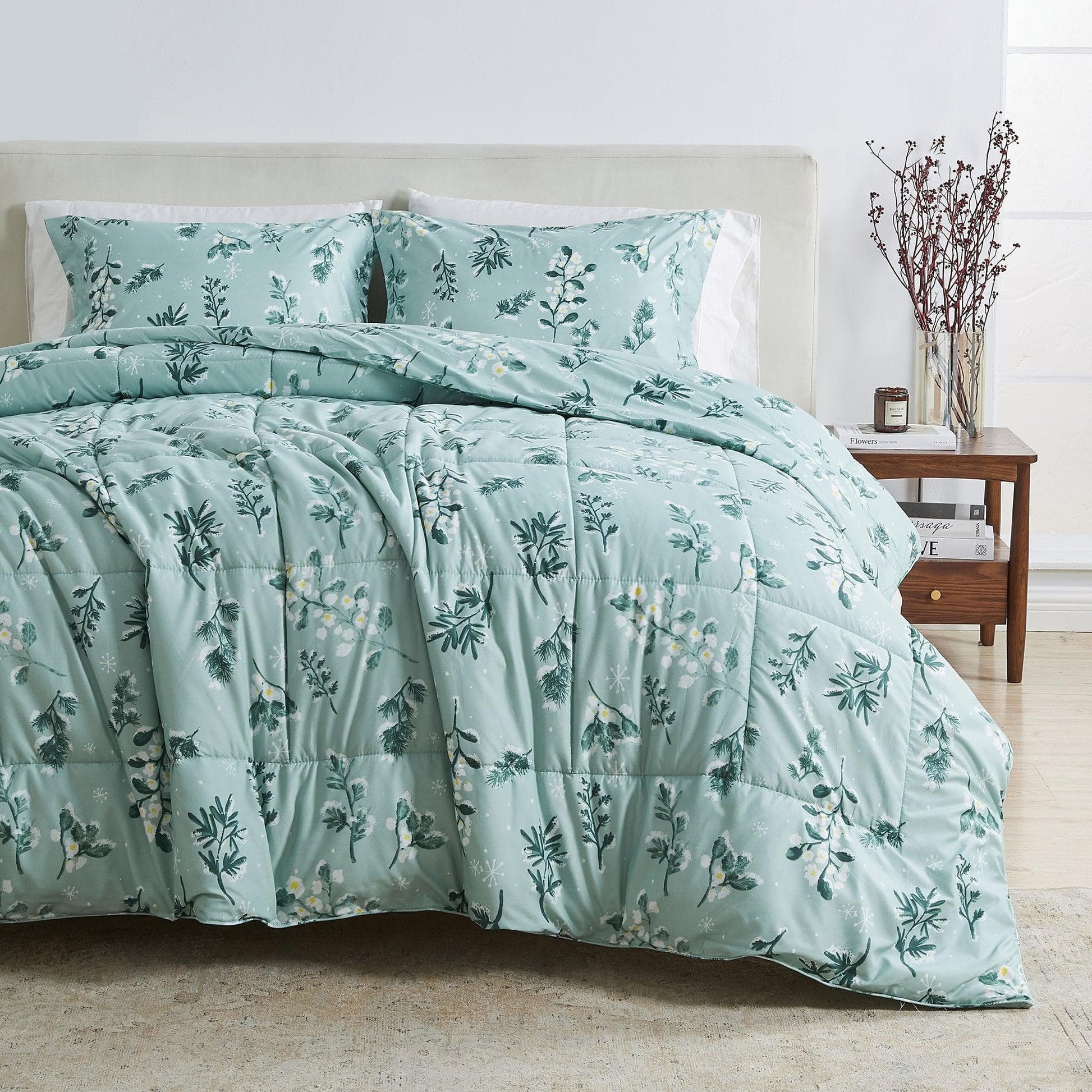 Teal floral comforter set on a bed in a bedroom setting.
