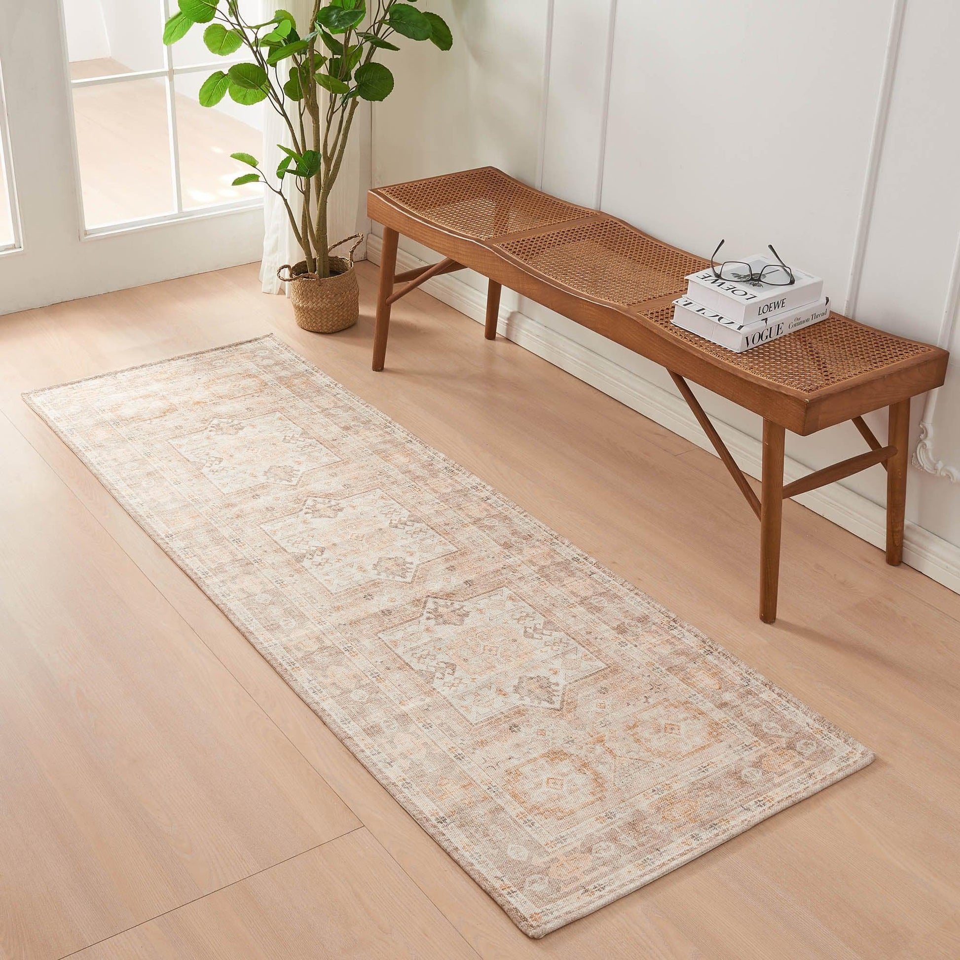 Long rectangular rug on a wooden floor with a wooden bench and plant in the background.