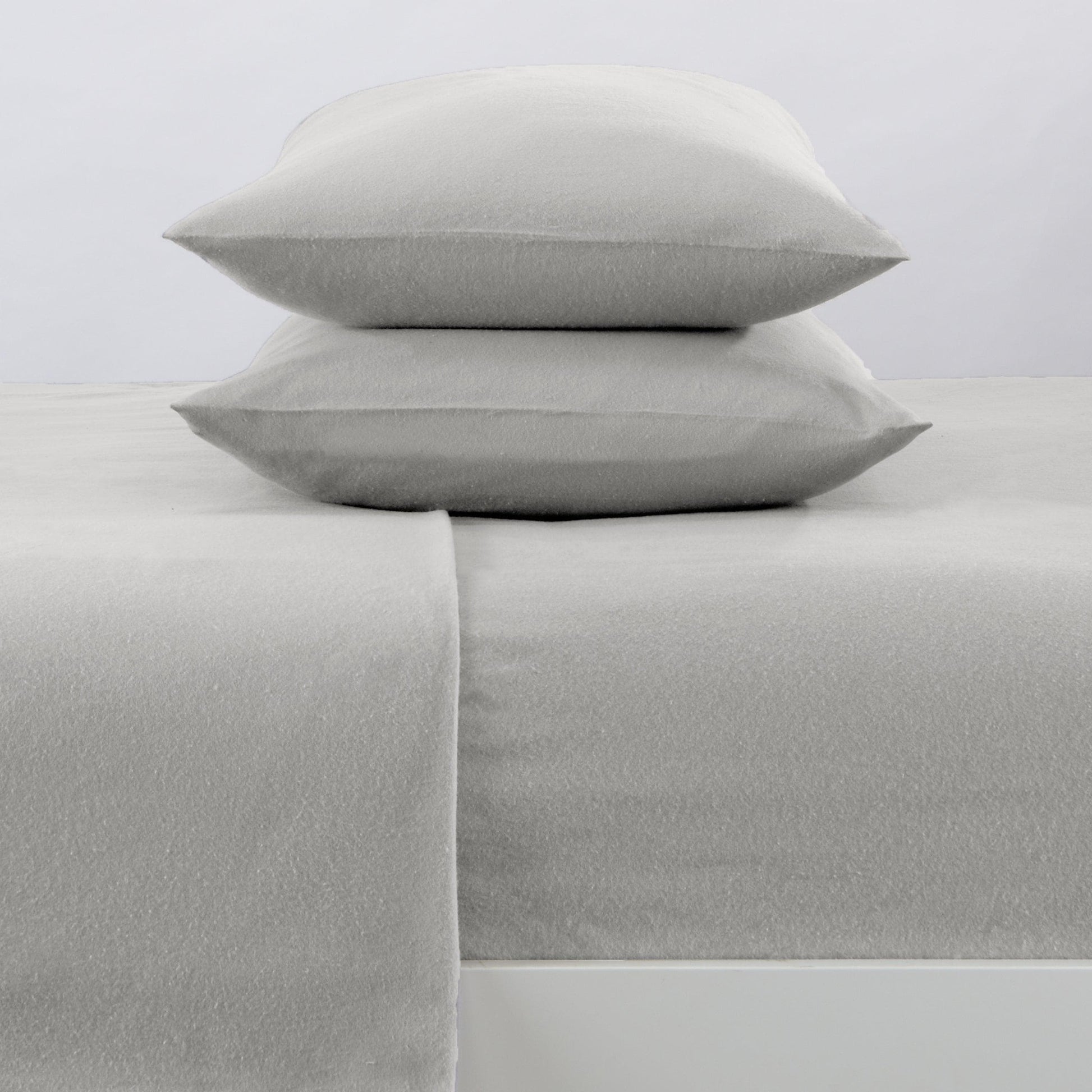 Gray bed sheets and pillows on a light gray background