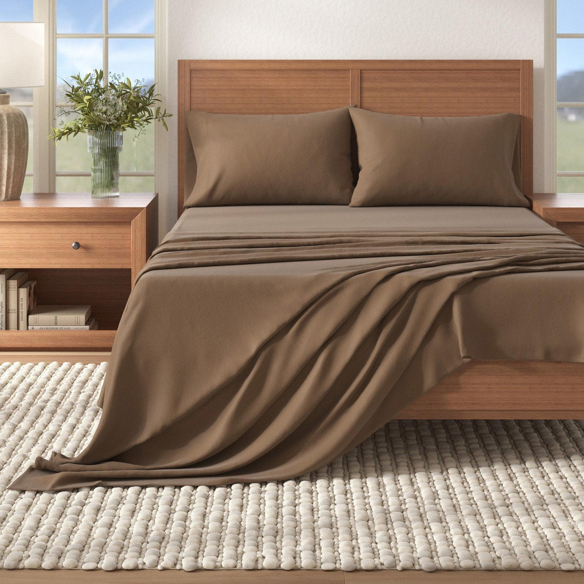 Brown bedspread on a wooden bed in a bright bedroom with windows and decor.