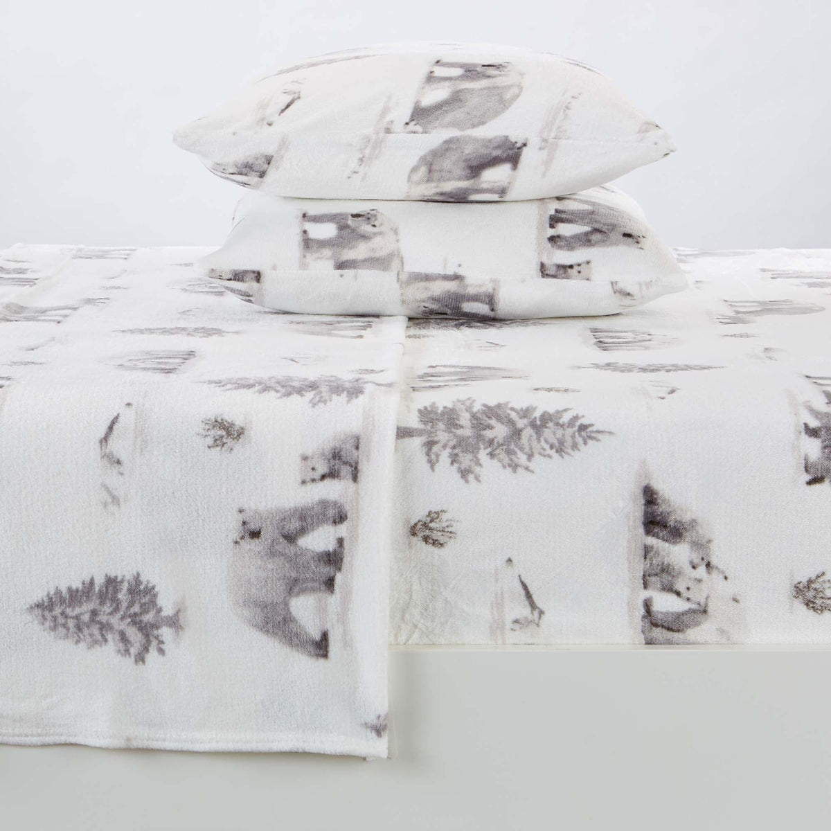 Bedding set with bear and pine tree pattern on a light gray background
