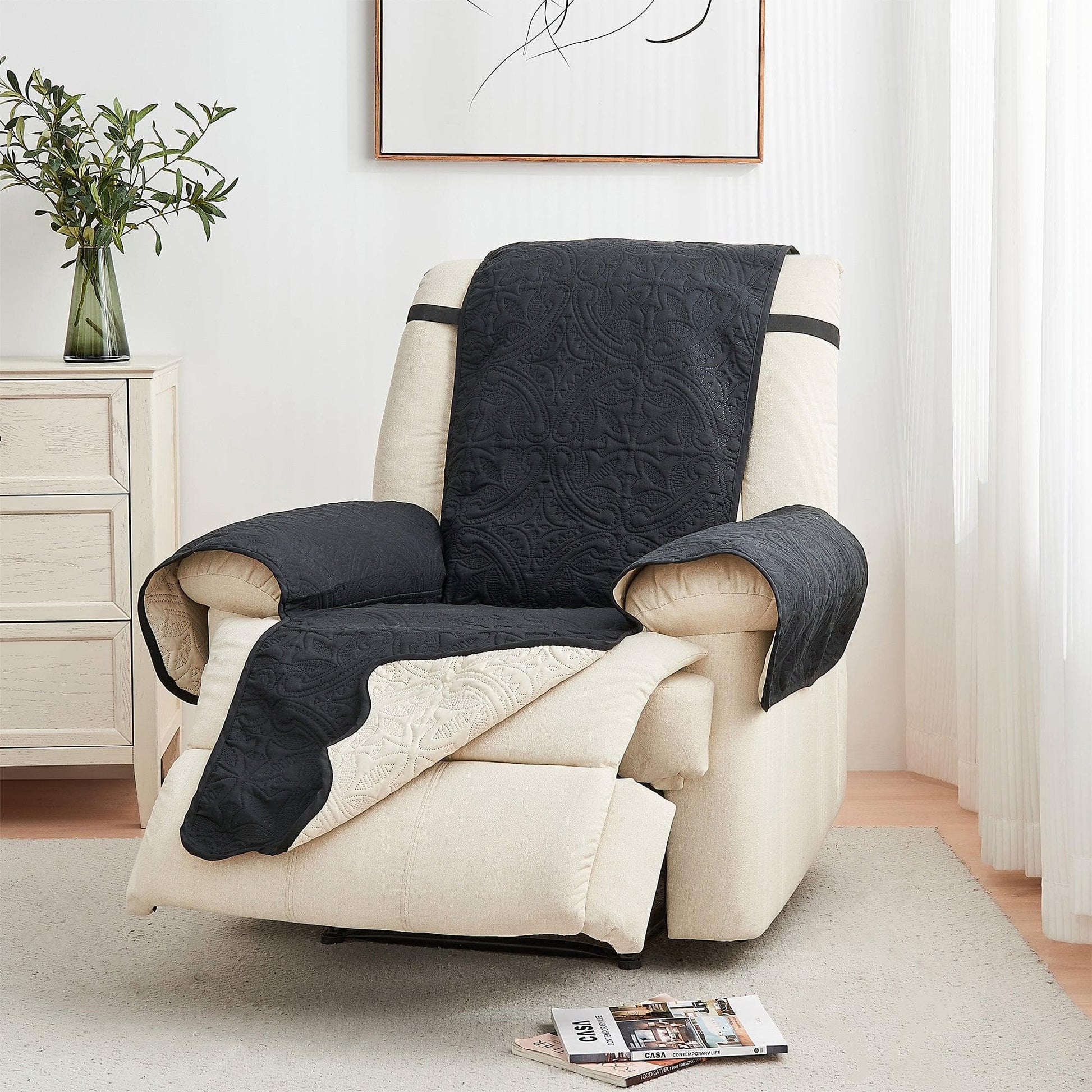 Beige armchair with a dark quilt draped over it in a living room setting.