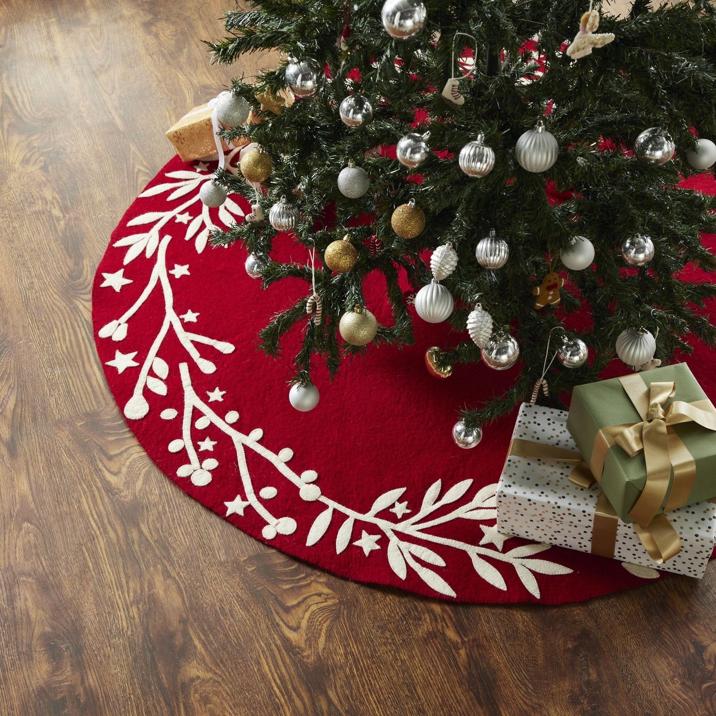 Handmade Felt Branches and Stars Red Christmas Tree Skirt 60 under a decorated Christmas tree with gifts.