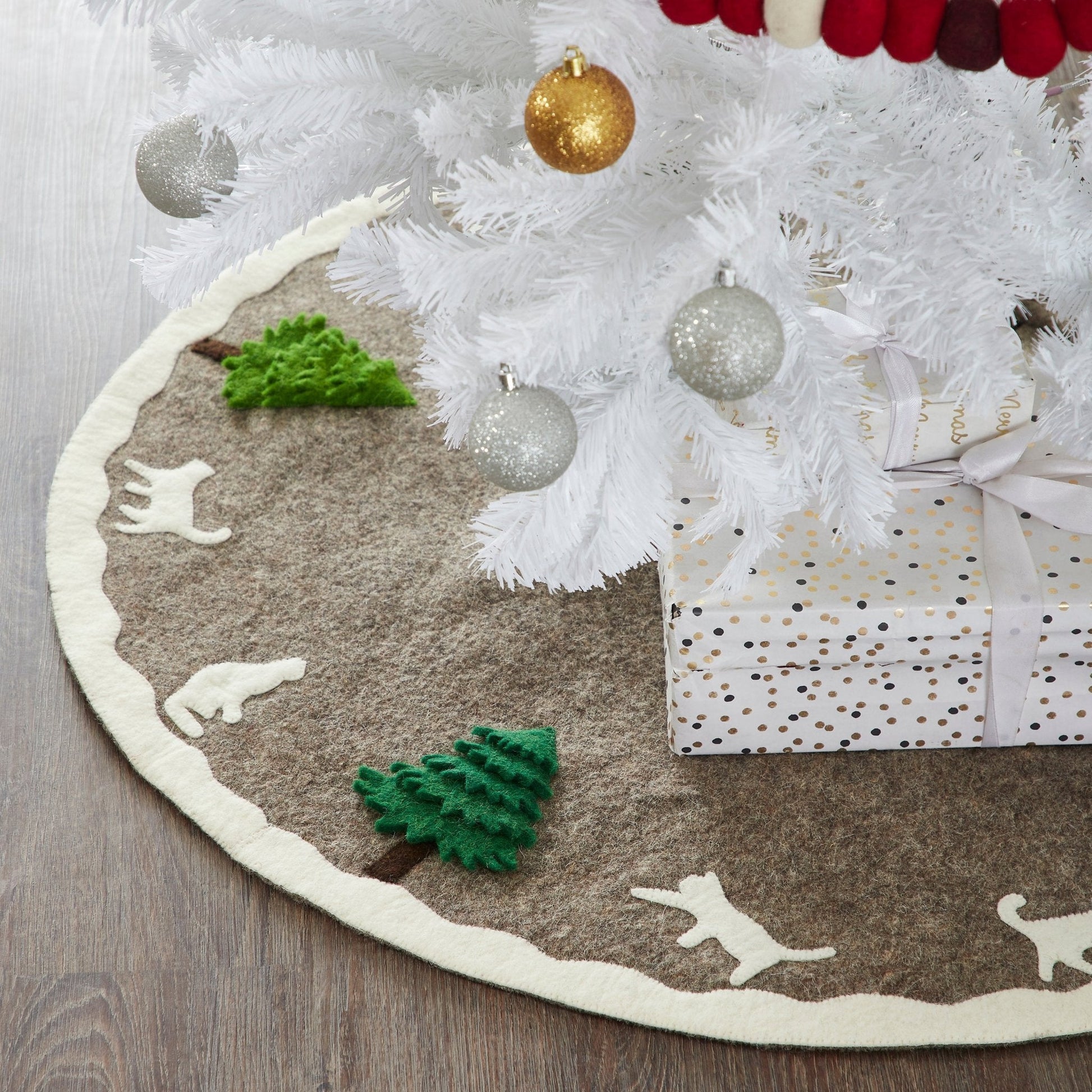 Handmade Felted Cats and Green Trees Grey Christmas Tree Skirt displayed under a white Christmas tree with decorations.