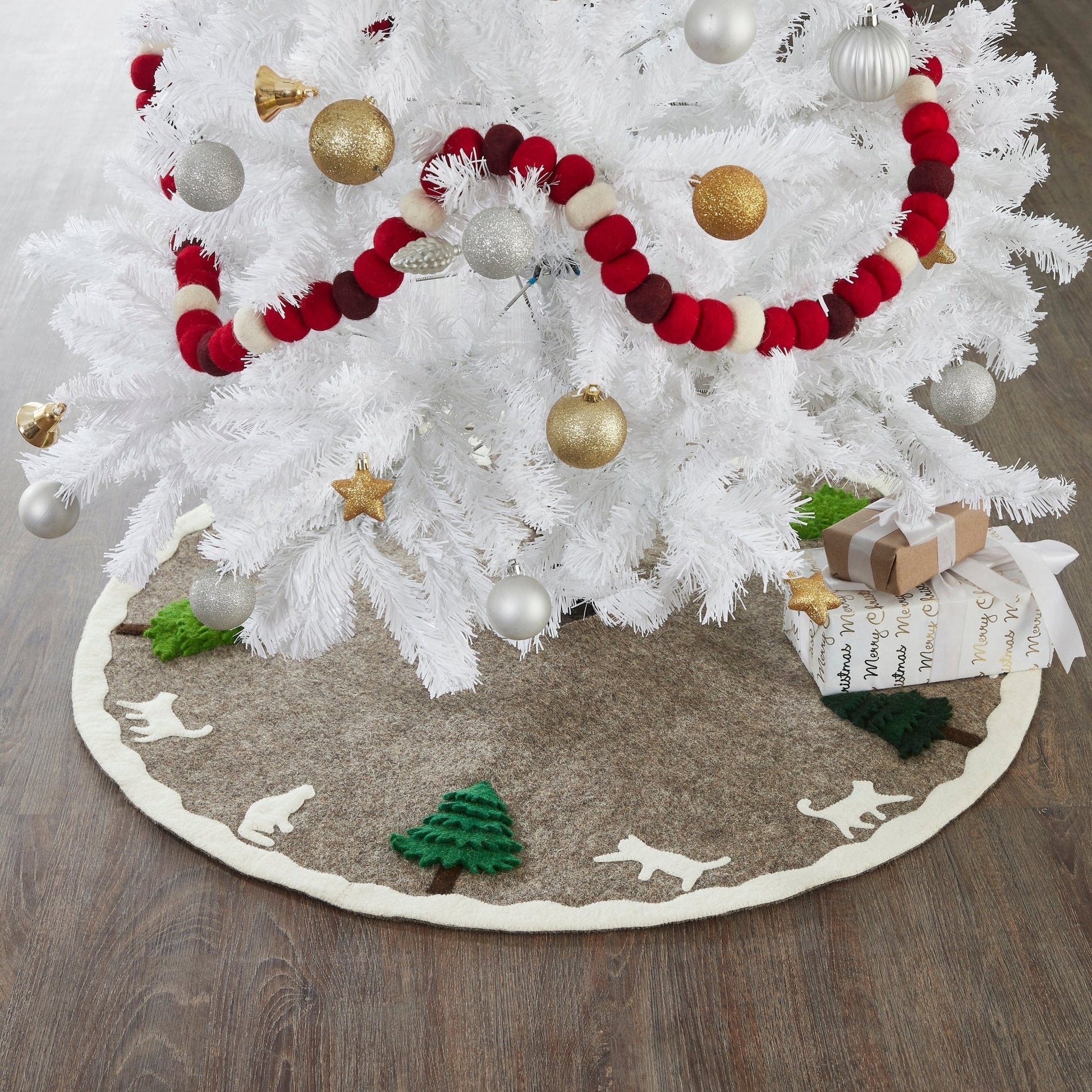 Handmade Felted Cats and Green Trees Grey Christmas Tree Skirt under a white tree with ornaments and gifts.