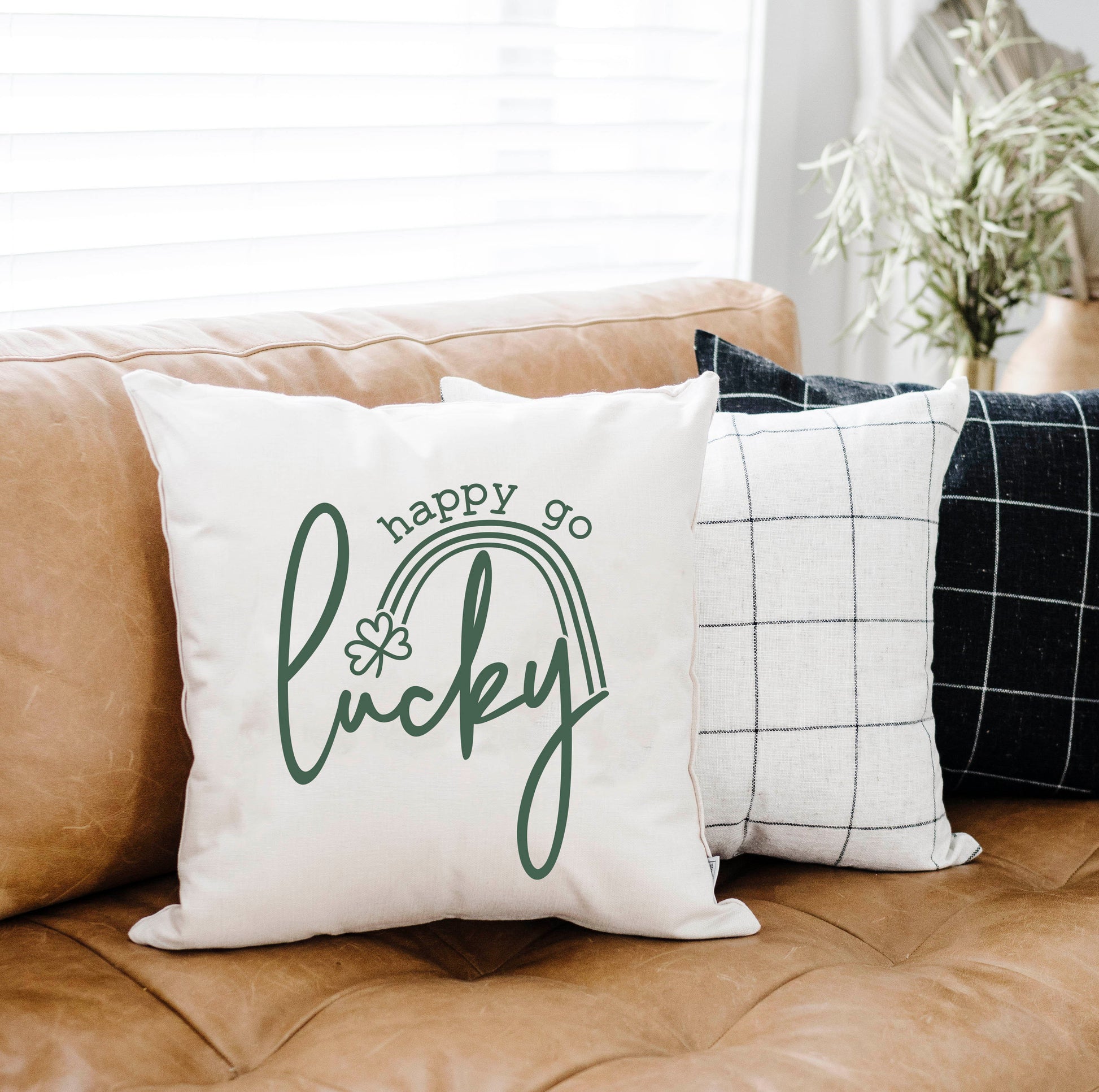 Happy Go Lucky 18x18 inch St Patrick's Day Pillow Cover on a couch with decorative pillows.