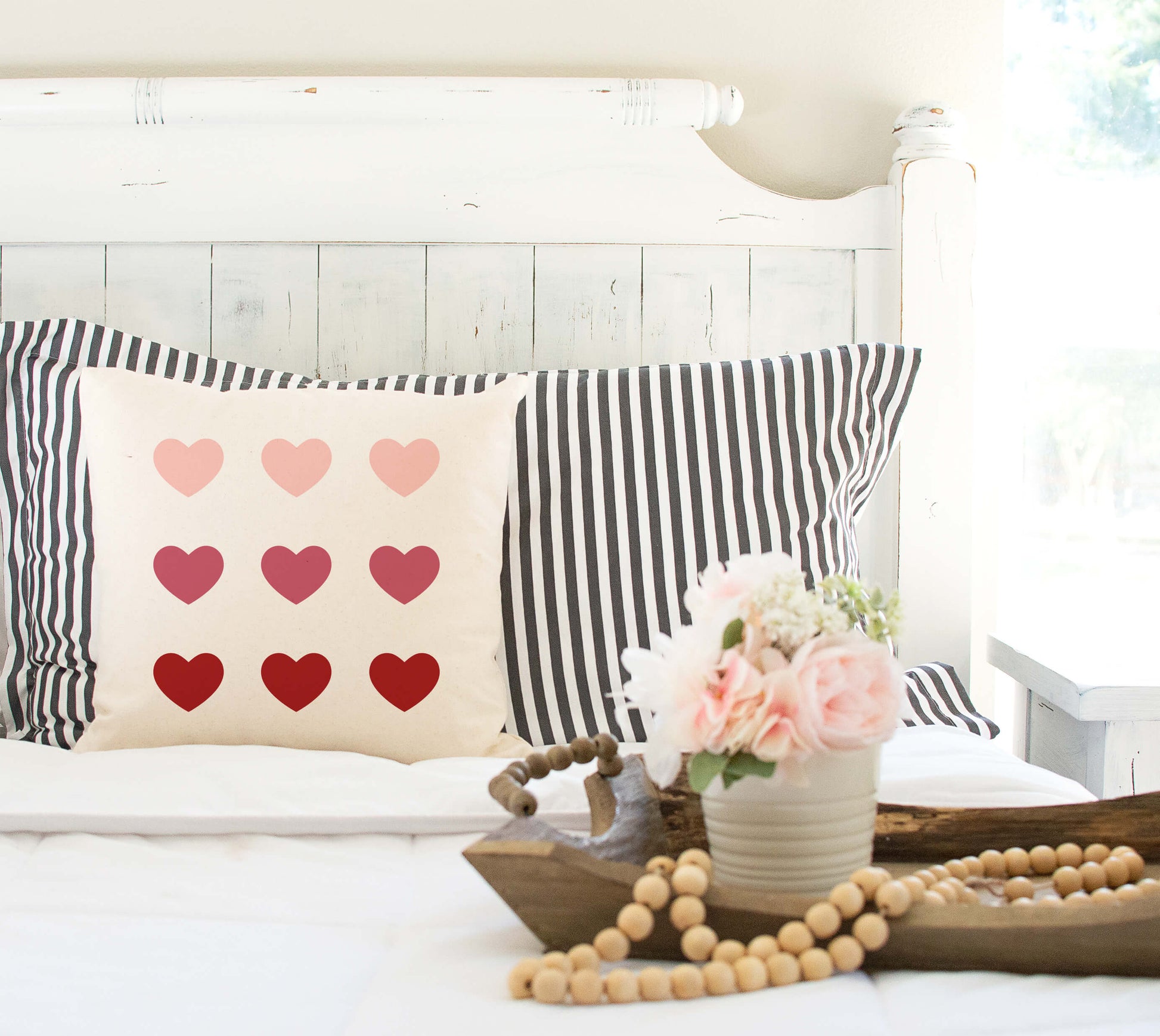 9 Hearts Valentine's Day Throw Farmhouse Pillow Cover 18x18 displayed on a bed with striped pillows and decorative accents.