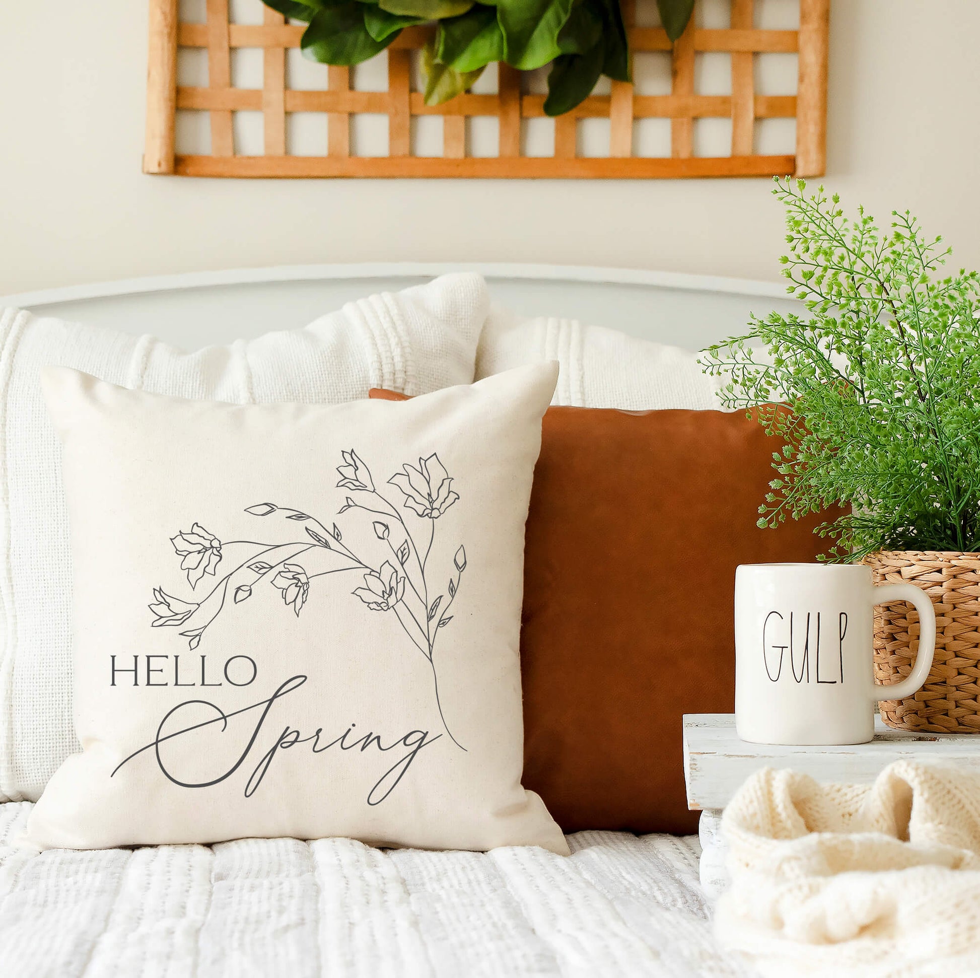 Hello Spring Floral Pillow Cover on a couch, showcasing spring decor with a natural, charcoal design.