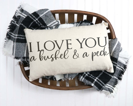 I Love You A Bushel and A Peck 12x20 inch Pillow Cover placed on a wooden tray with a checkered throw blanket.
