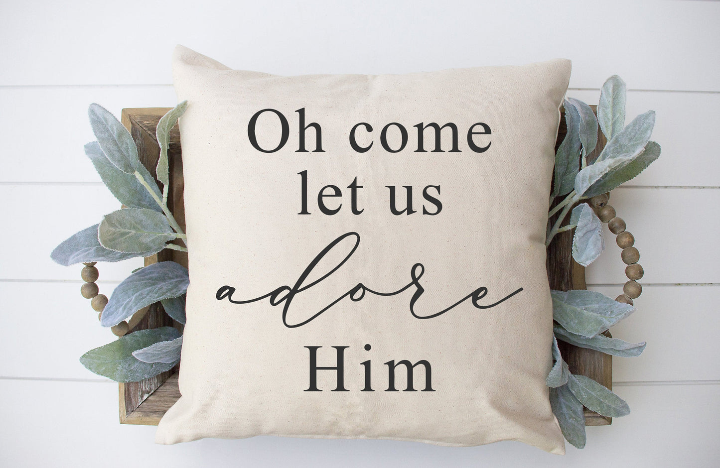 Oh Come Let Us Adore Him 18x18 inch Pillow Cover displayed with greenery decor on a wooden tray.