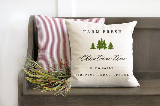 Farm Fresh Christmas Trees 18x18 inch Pillow Cover on a rustic bench with greenery accents.