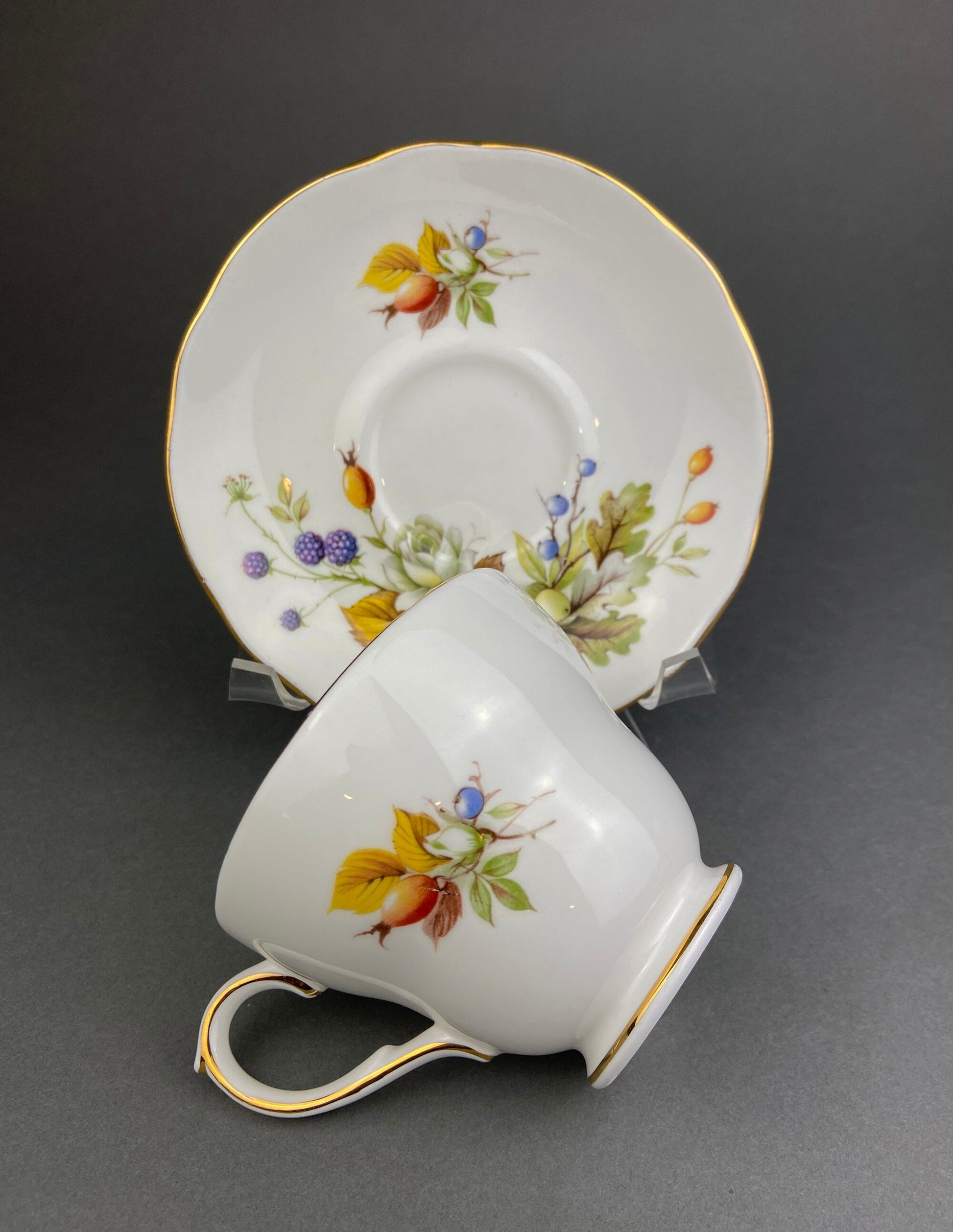 Ceramic cup and saucer with floral design on a gray background