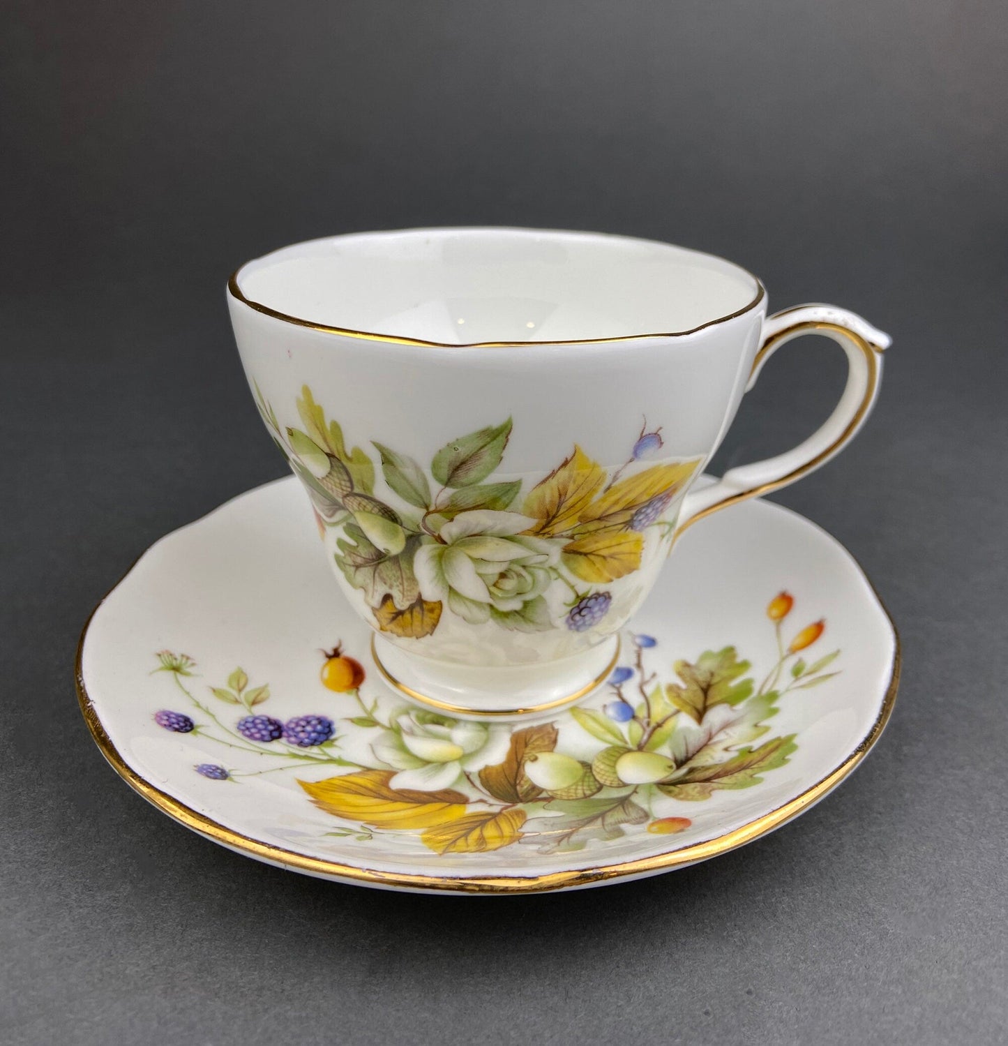 Teacup and saucer with floral design on a gray background