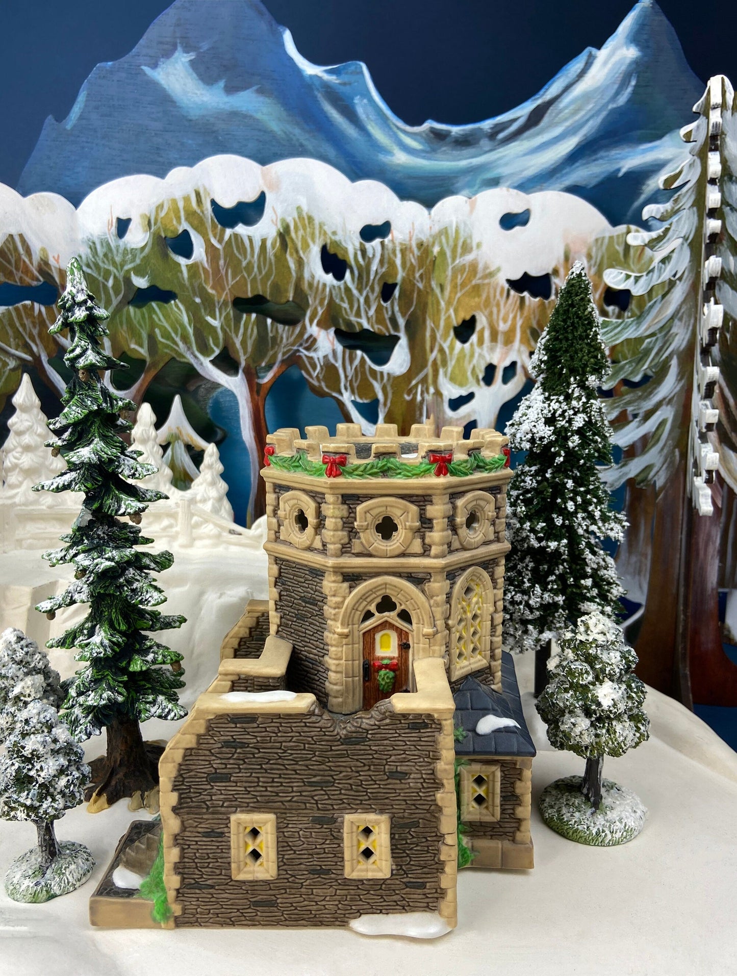 Decorative gingerbread house with snowy mountain and trees in the background