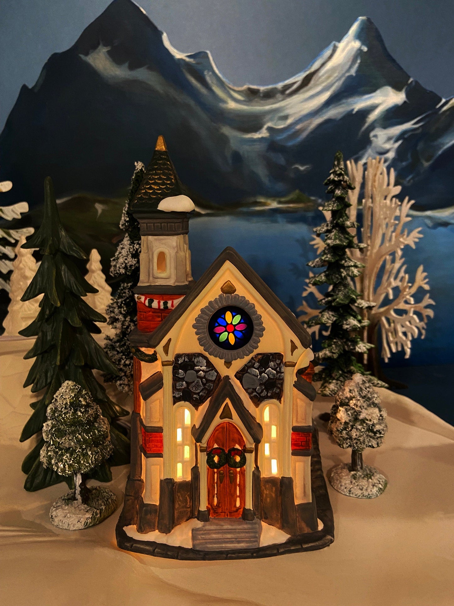Christmas Village Church with Stained Glass Window. Illuminated House of Worship. Holiday Decor. Christmas Celebration.