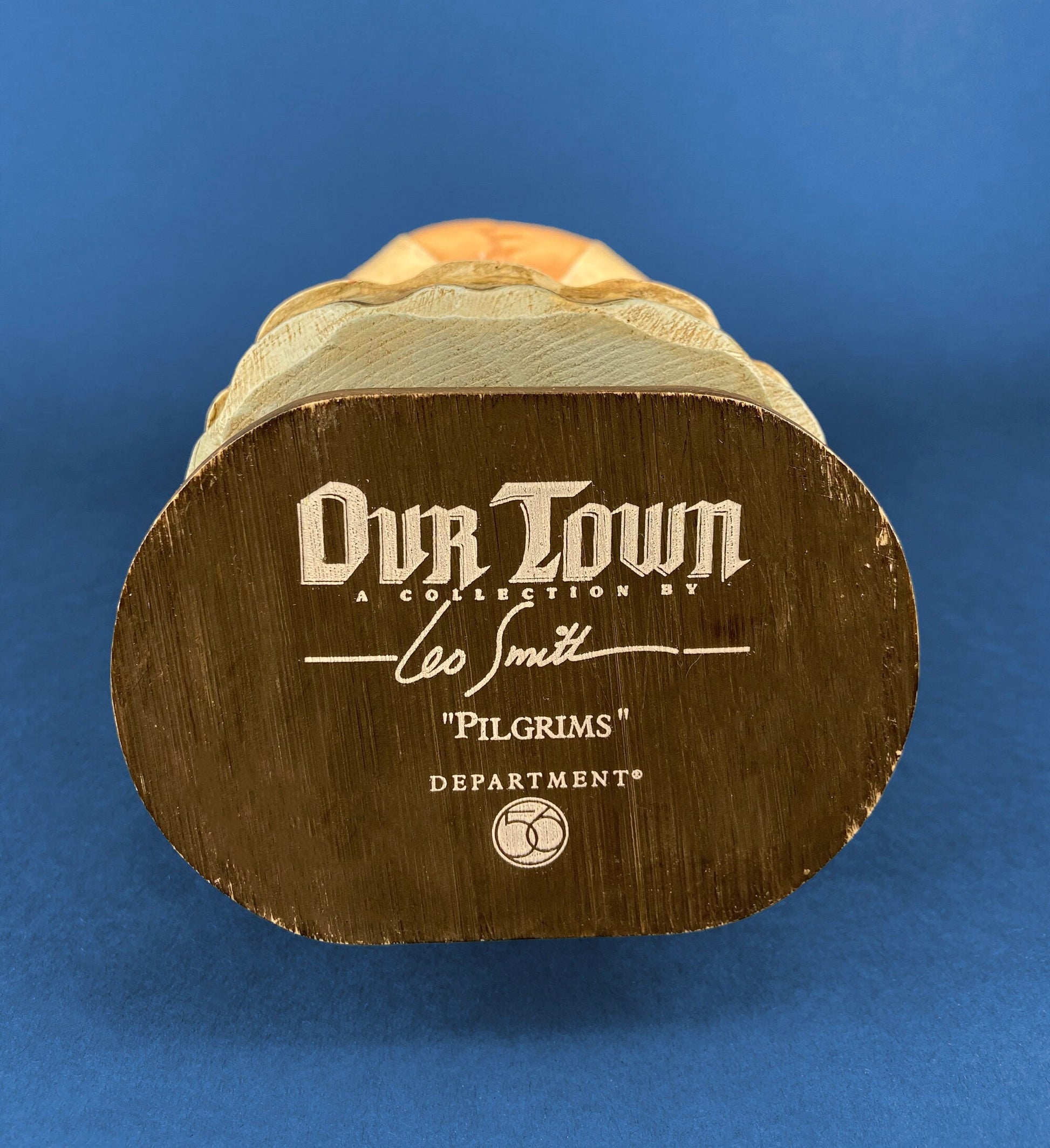 Wooden figurine with 'Our Town' branding on a blue background