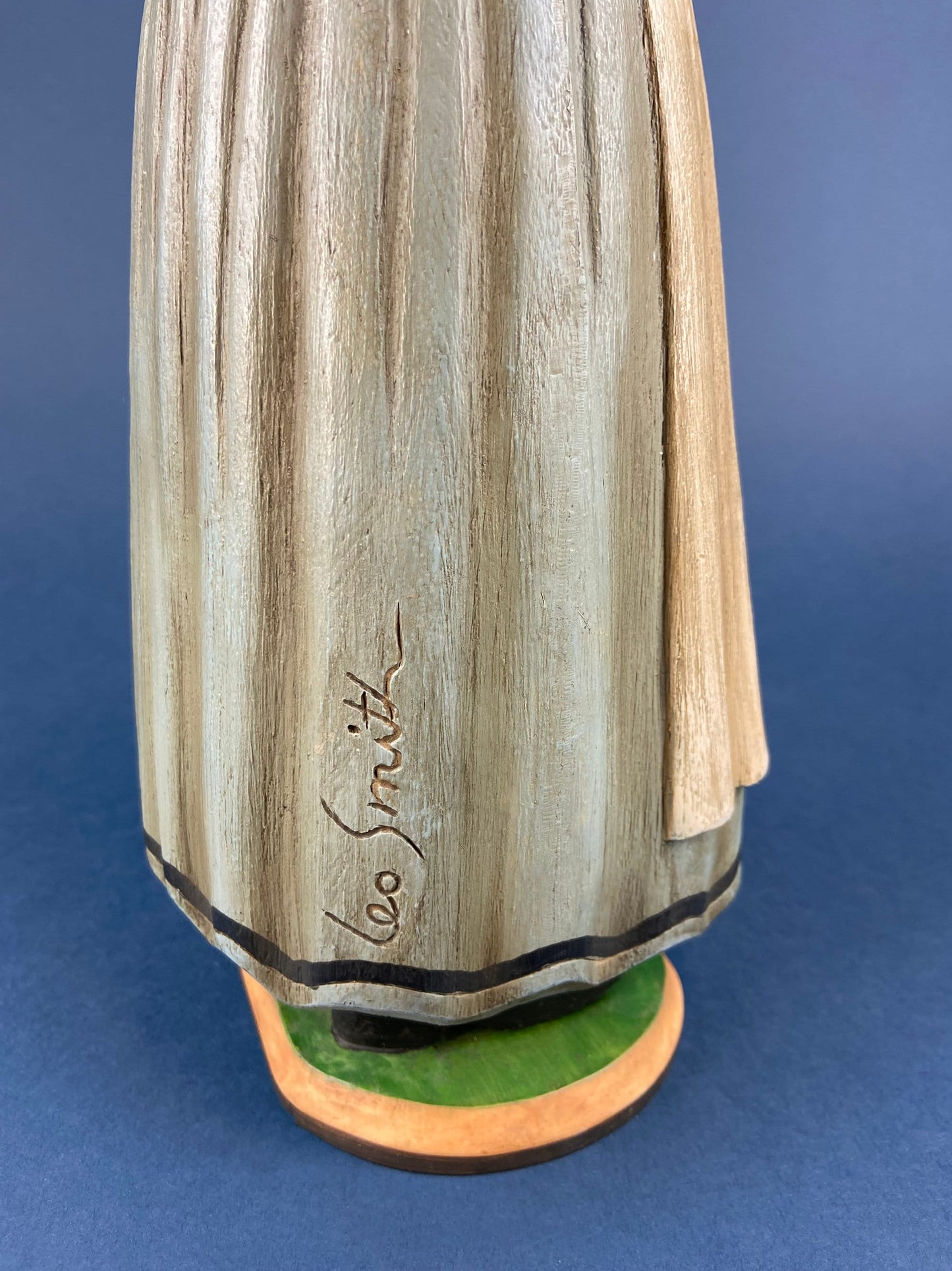 Wooden sculpture with 'Leo Smith' engraving on a blue background