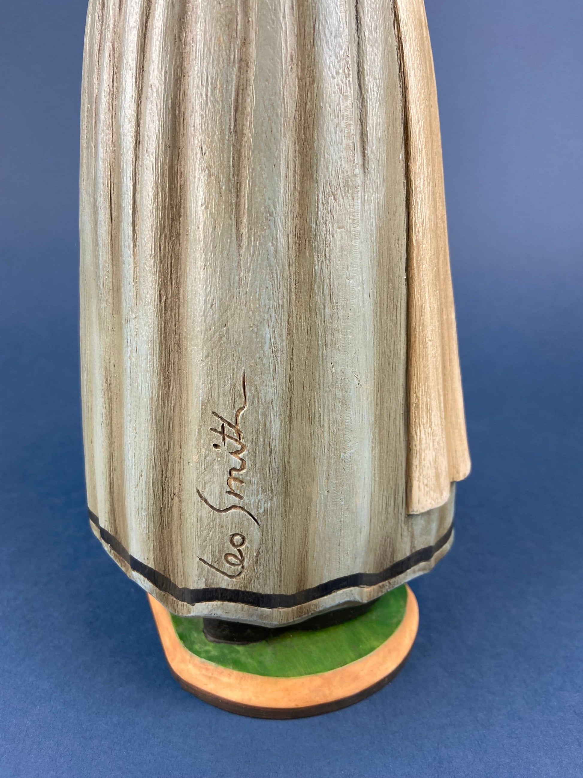 Wooden sculpture with 'Leo Smith' engraving on a blue background