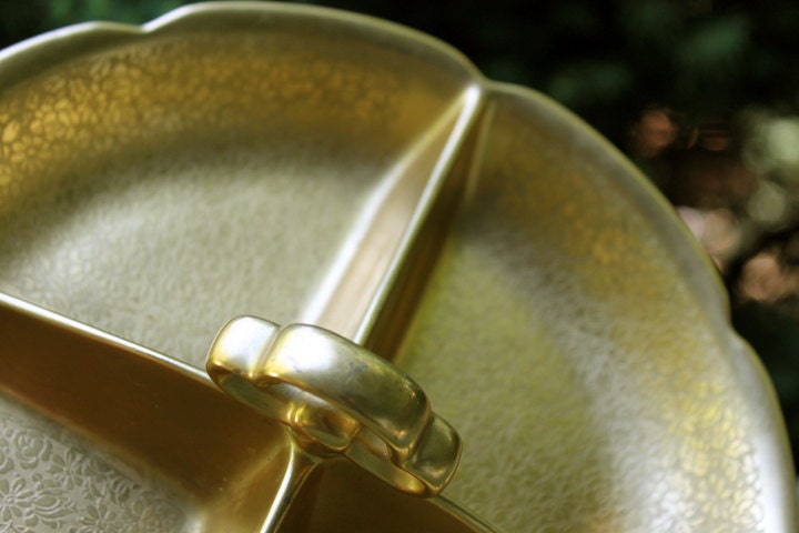 Gold decorative item with a handle on a textured surface