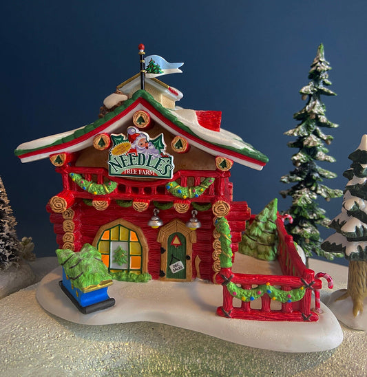 Decorative Christmas tree farm house ornament with trees and snow on a dark blue background