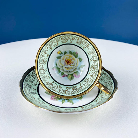 Teacup and saucer with floral design on a white surface