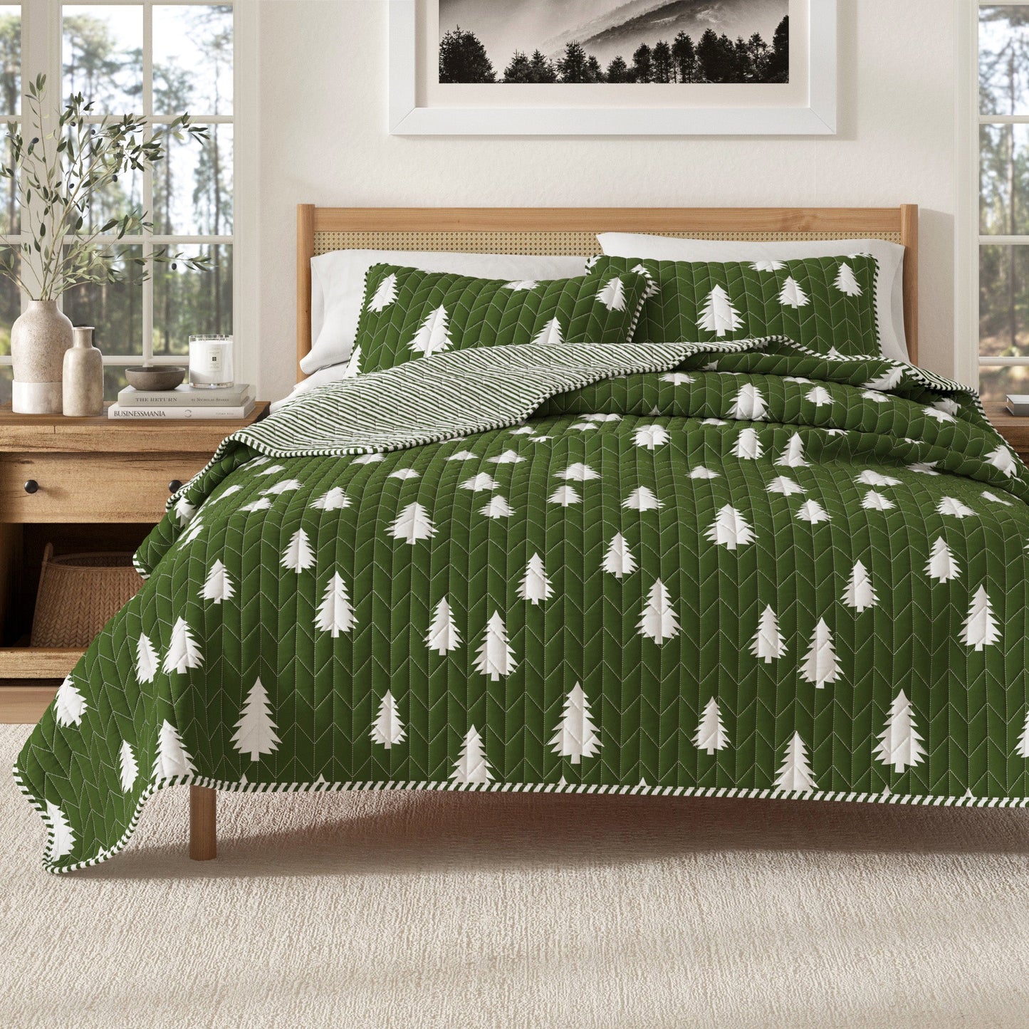 Green quilt with white tree pattern on a bed in a bedroom setting