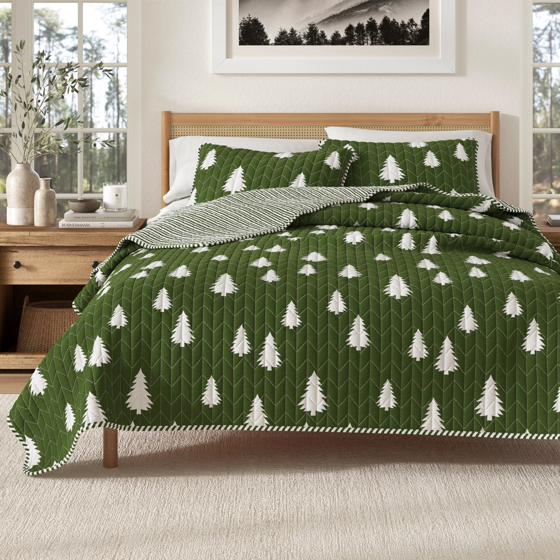 Green quilt with white tree pattern on a bed in a bedroom setting