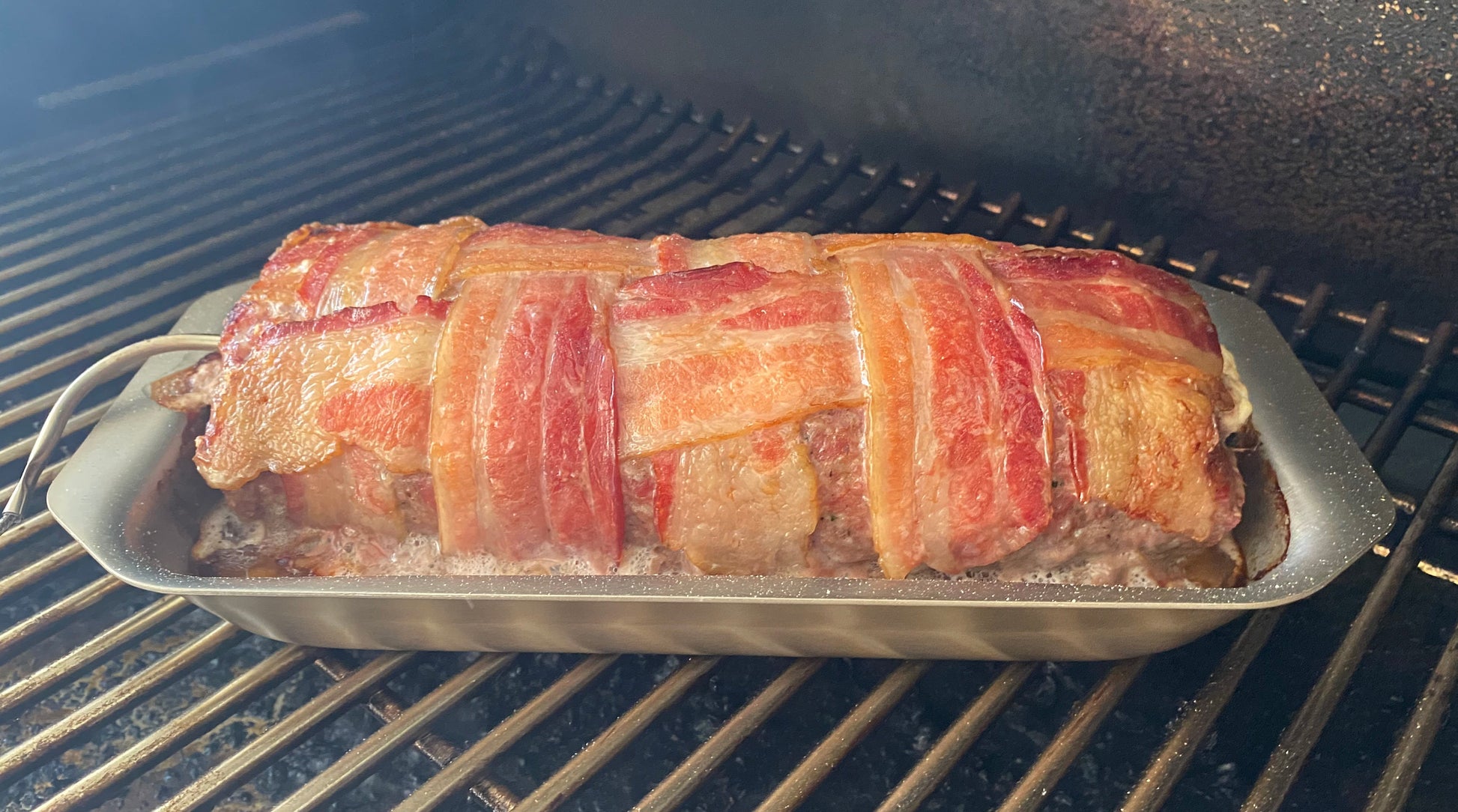Bacon-wrapped meatloaf on a grill