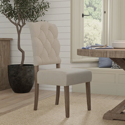 Newberry Side Chairs with weathered wood legs and button-tufted detail in a cozy dining room setting.