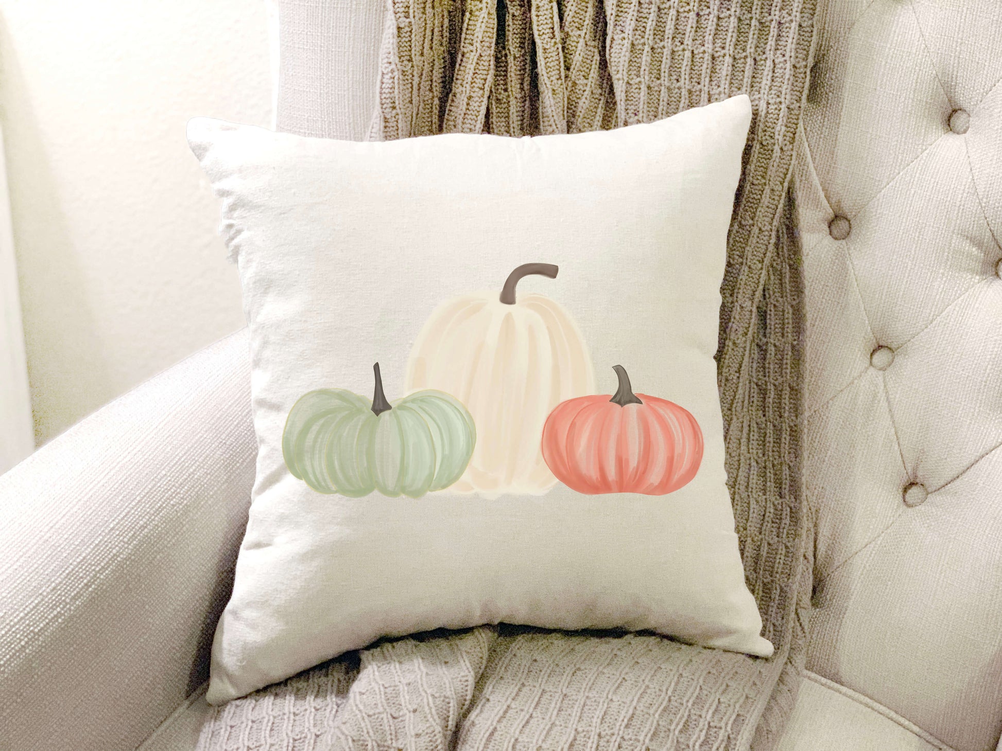 Pumpkin Trio Pillow Cover 18x18 inch featuring soft pumpkins in green, white, and orange on a cozy couch.