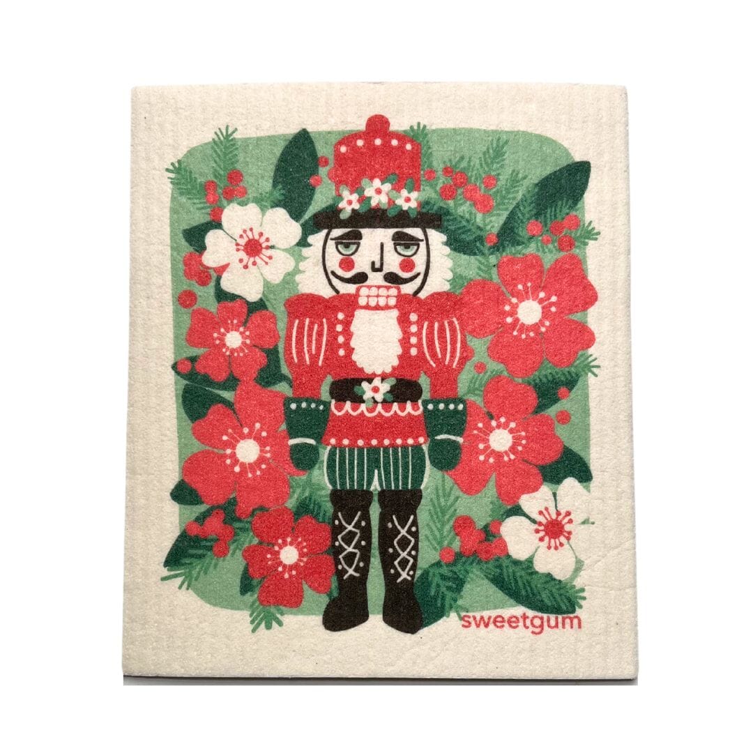Decorative kitchen towel with a nutcracker design surrounded by flowers on a beige background.